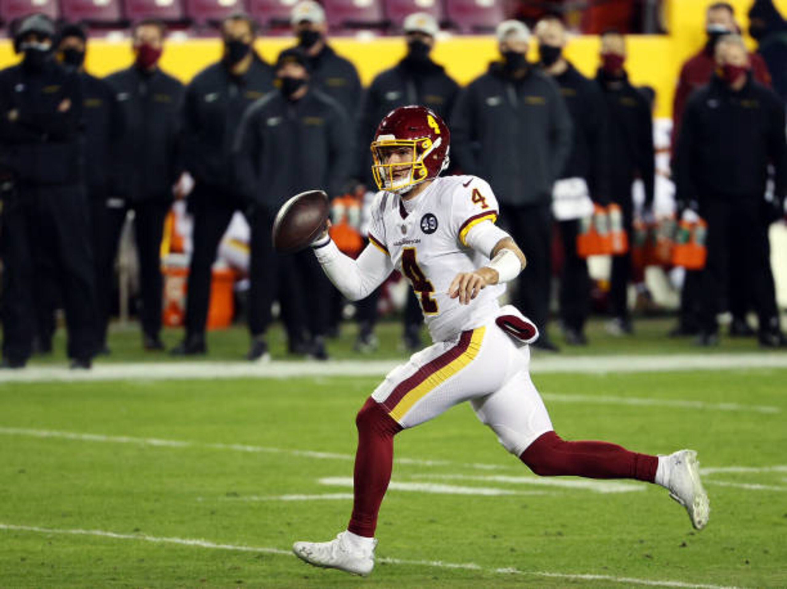 LANDOVER, MARYLAND - JANUARY 09:  Quarterback Taylor Heinicke #4 of the Washington Football Team scrambles during the 2nd quarter of the game against the Tampa Bay Buccaneers at FedExField on January 09, 2021 in Landover, Maryland. (Photo by Patrick Smith/Getty Images)