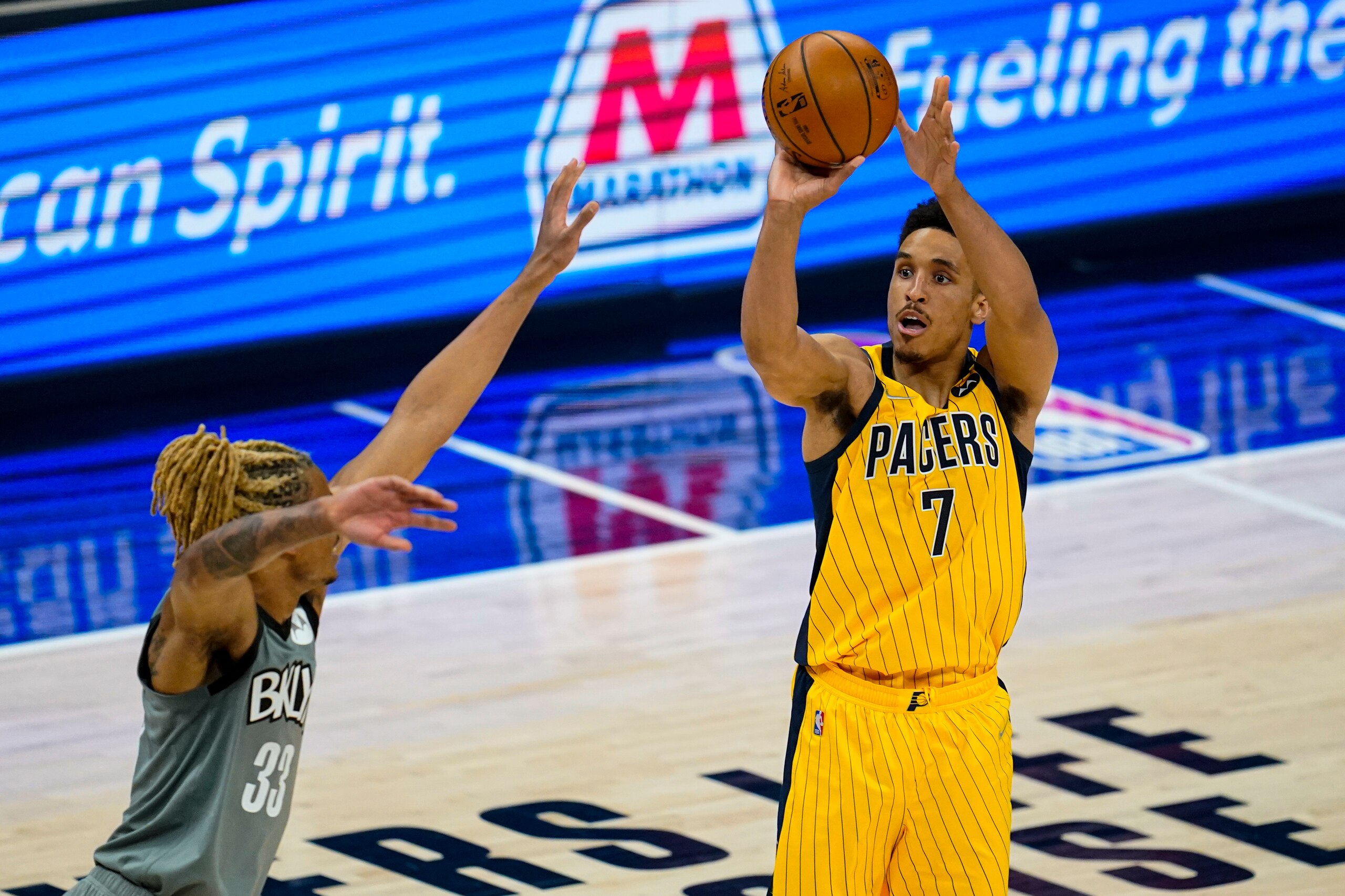Indiana Pacers guard Malcolm Brogdon (7) shoots over Brooklyn Nets forward Nicolas Claxton (33) during the first half of an NBA basketball game in Indianapolis, Wednesday, March 17, 2021. (AP Photo/Michael Conroy)
