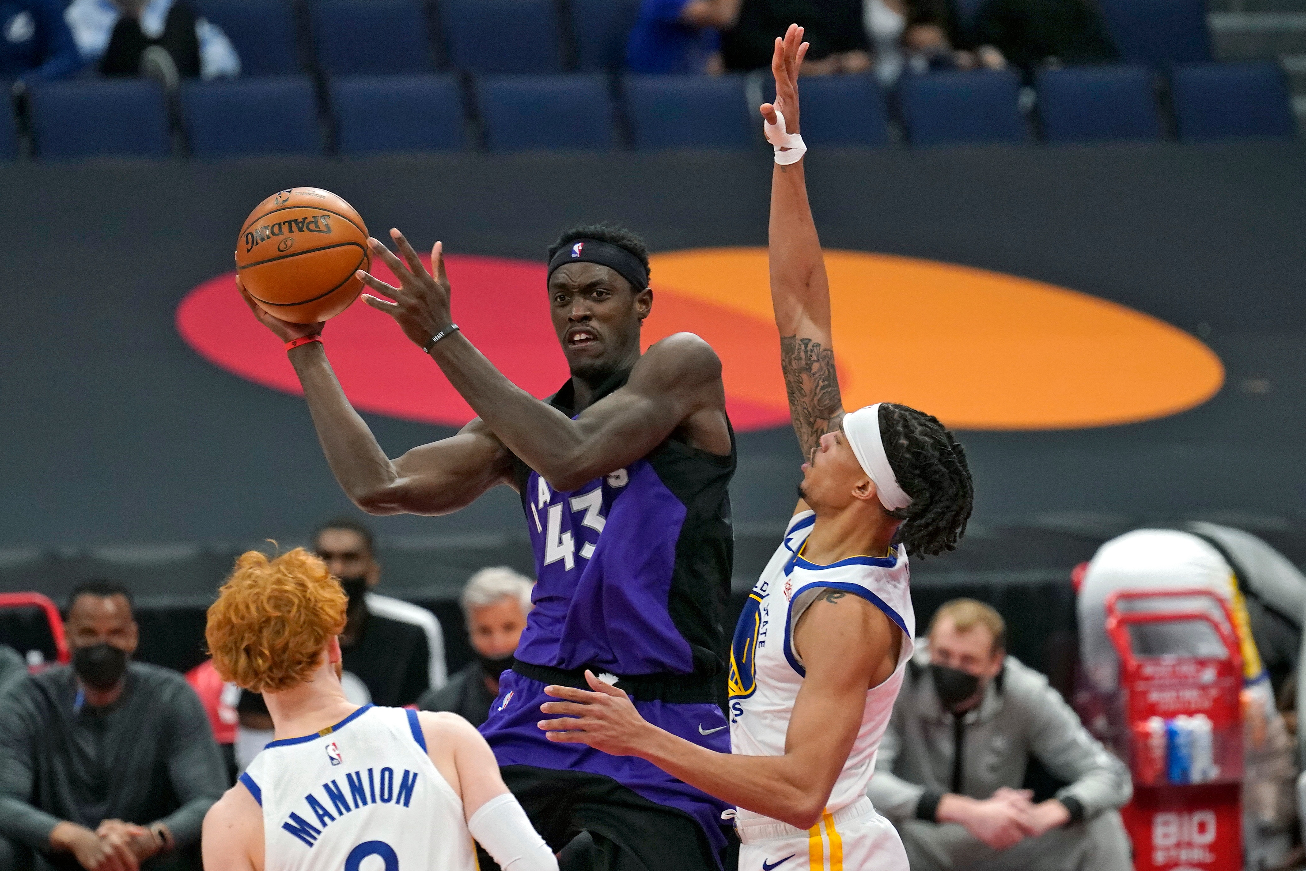 Toronto Raptors forward Pascal Siakam (43) passes the ball between Golden State Warriors guard Nico Mannion (2) and guard Damion Lee (1) during the second half of an NBA basketball game Friday, April 2, 2021, in Tampa, Fla. (AP Photo/Chris O'Meara)