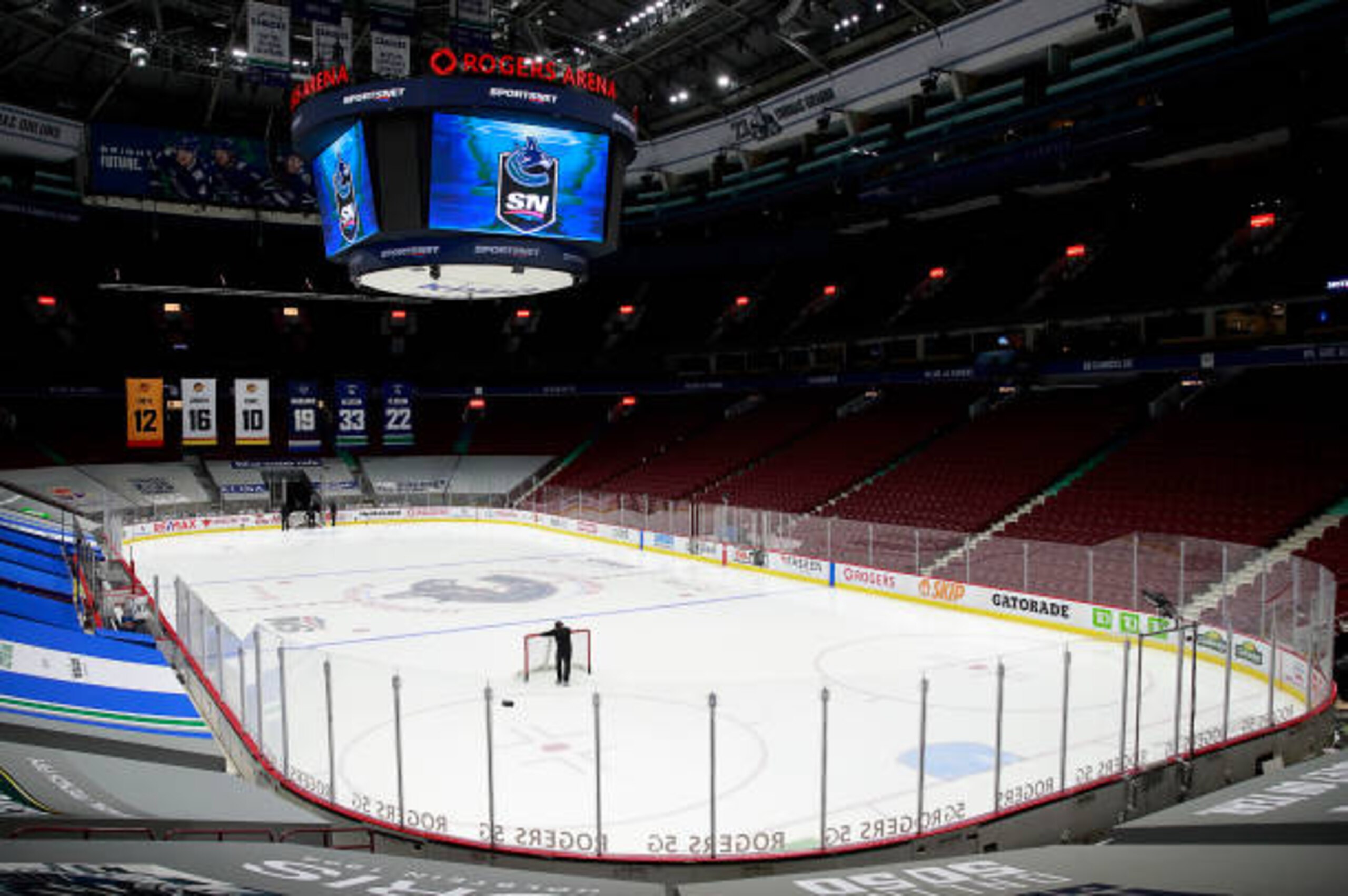 VANCOUVER, BC - MARCH 31: A rink attendant pushes a game net off the ice after the NHL game between the Calgary Flames and the Vancouver Canucks was postponed due to a positive COVID test result of a player at Rogers Arena on March 31, 2021 in Vancouver, British Columbia, Canada. (Photo by Jeff Vinnick/NHLI via Getty Images) VANCOUVER, BC - MARCH 31: A rink attendant pushes a game net off the ice after the NHL game between the Calgary Flames and the Vancouver Canucks was postponed due to a positive COVID test result of a player at Rogers Arena on March 31, 2021 in Vancouver, British Columbia, Canada. (Photo by Jeff Vinnick/NHLI via Getty Images)