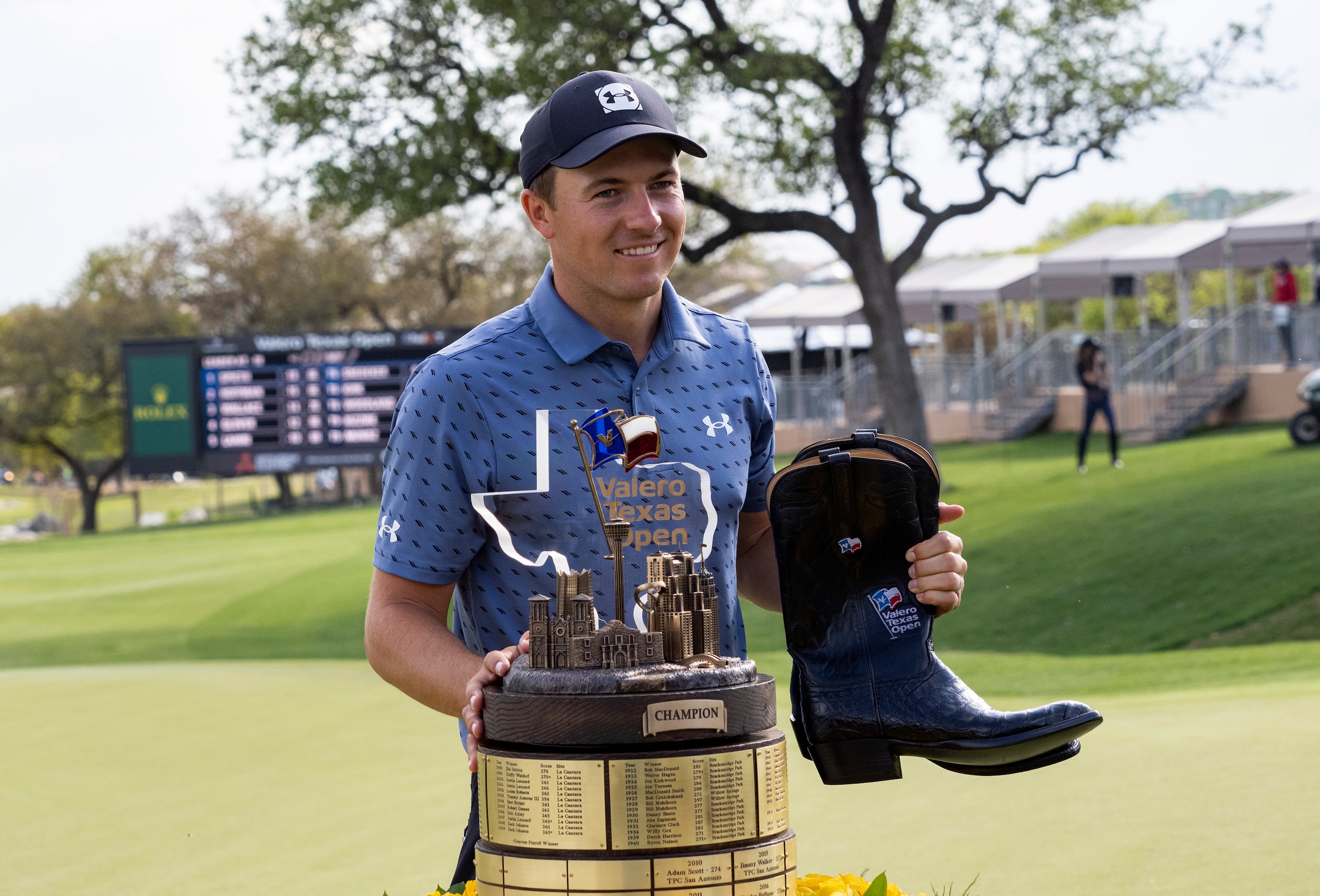 Jordan Spieth stands with the Valero Texas Open trophy and the boots awarded to the champion of the Valero Texas Open golf tournament in San Antonio, Sunday, April 4, 2021. (AP Photo/Michael Thomas)