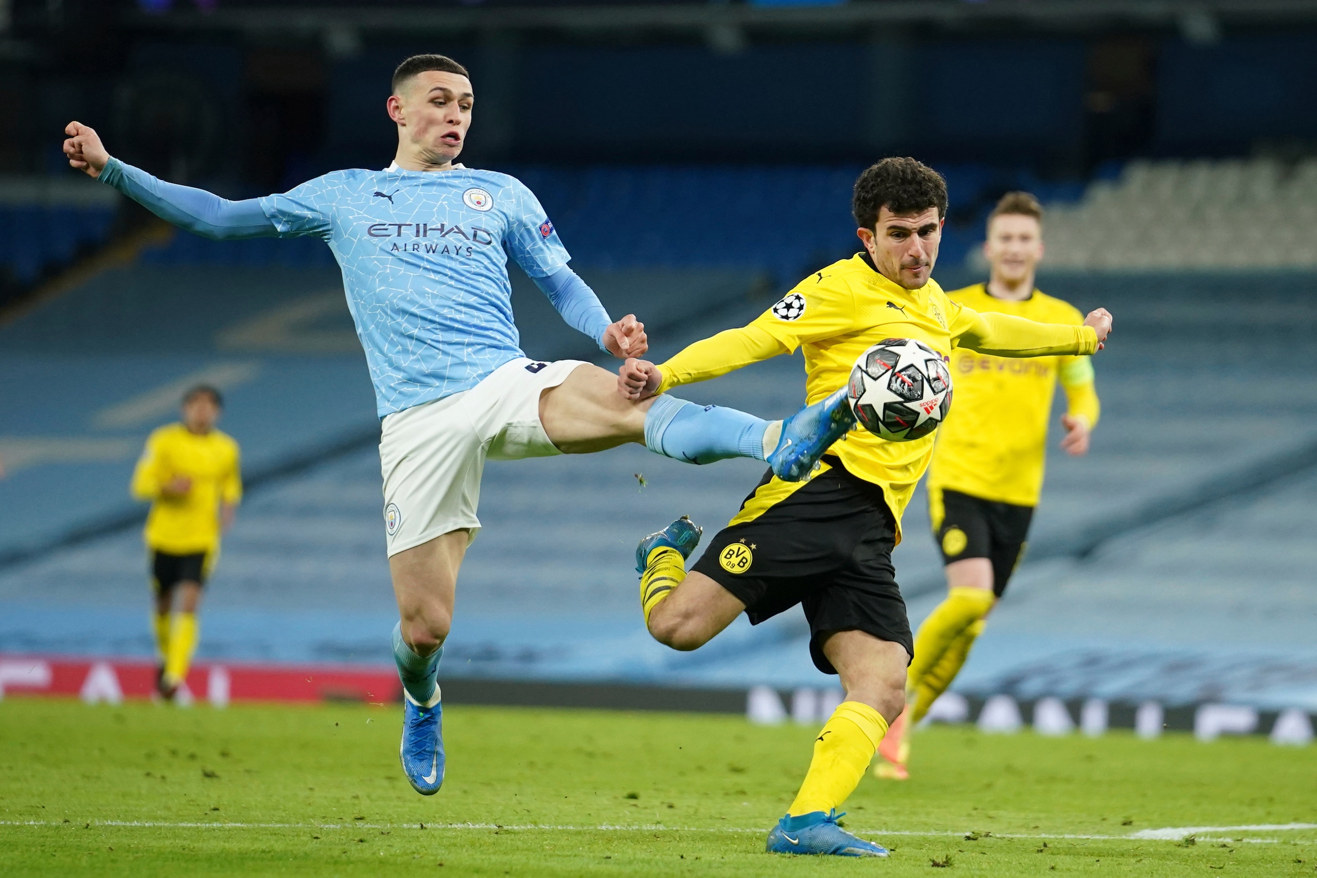 Manchester City's Phil Foden, left, challenges for the ball with Dortmund's Mateu Morey during the Champions League, first leg, quarterfinal soccer match between Manchester City and Borussia Dortmund at the Etihad stadium in Manchester, Tuesday, April 6, 2021. (AP Photo/Dave Thompson)
