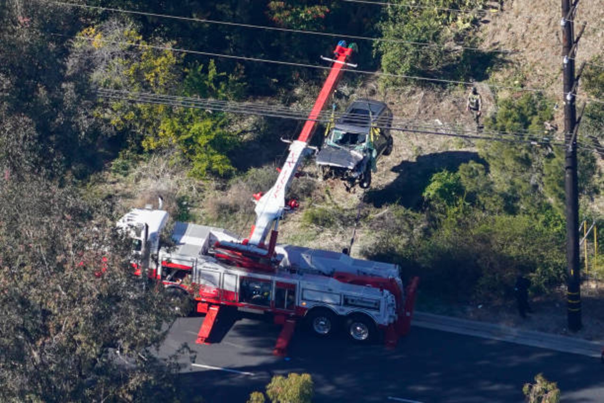 Rancho Palos Verdes, CA - February 23: Workers move a vehicle after a rollover accident involving golfer Tiger Woods on Tuesday, Feb. 23, 2021 in Rancho Palos Verdes, CA. Woods suffered leg injuries in the one-car accident and was undergoing surgery, authorities and his manager said.(Mark J. Terrill for For The Times)