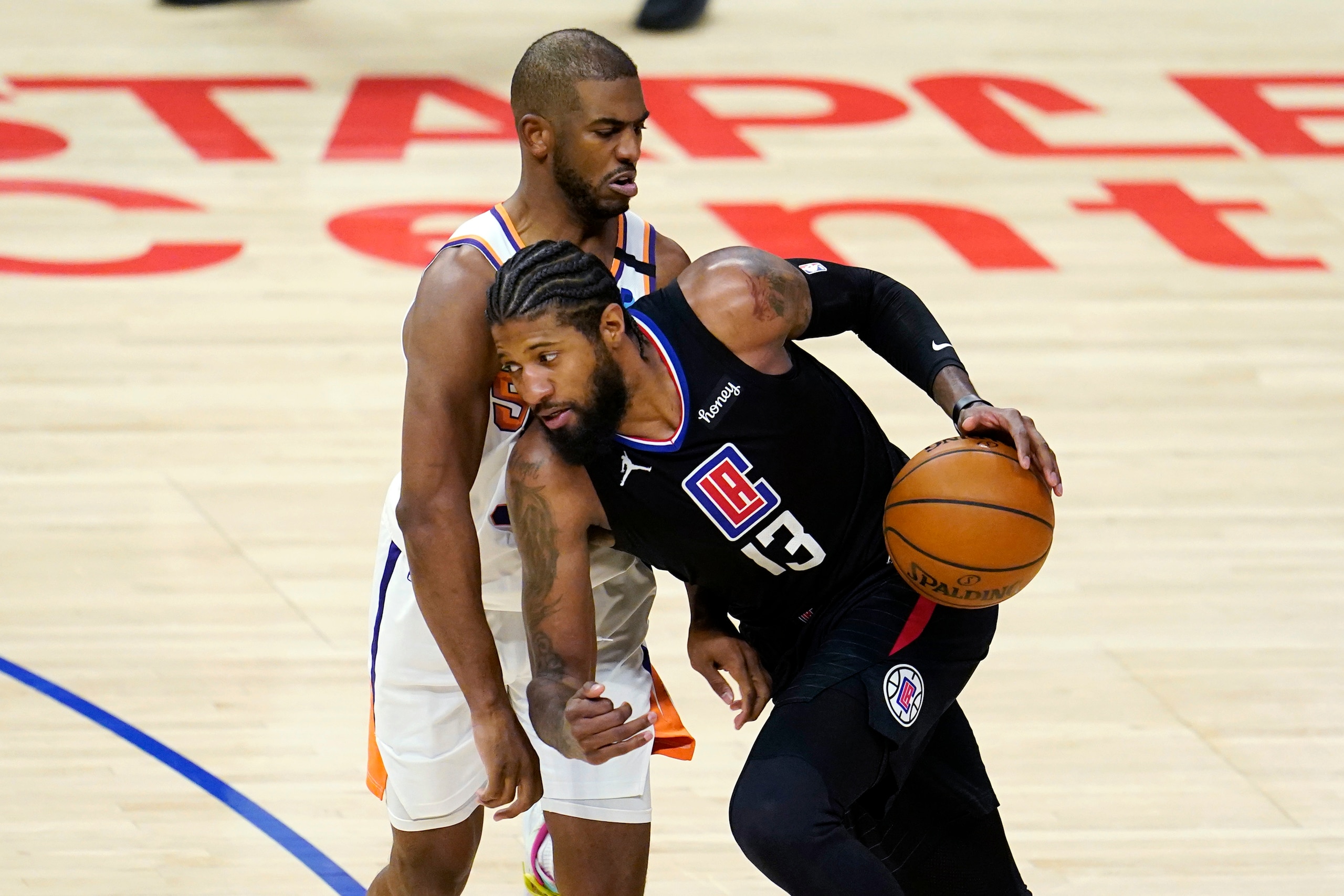 Los Angeles Clippers guard Paul George (13) is defended by Phoenix Suns guard Chris Paul during the second half of an NBA basketball game Thursday, April 8, 2021, in Los Angeles. (AP Photo/Marcio Jose Sanchez)