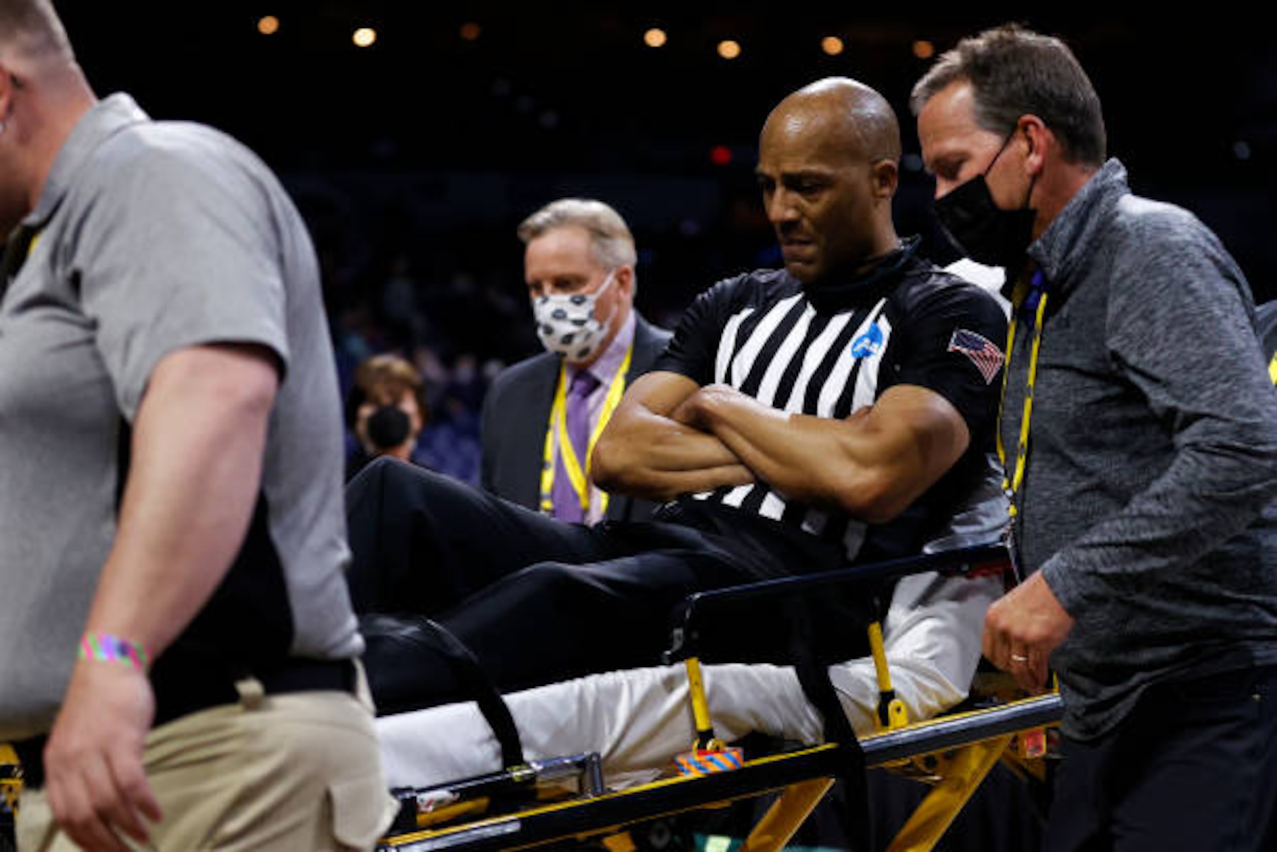 INDIANAPOLIS, INDIANA - MARCH 30: Referee Bert Smith is helped off the court by training staff and medical personnel after collapsing during the first half of the Elite Eight round game between the USC Trojans and the Gonzaga Bulldogs during the 2021 NCAA Men's Basketball Tournament at Lucas Oil Stadium on March 30, 2021 in Indianapolis, Indiana. (Photo by Jamie Squire/Getty Images)