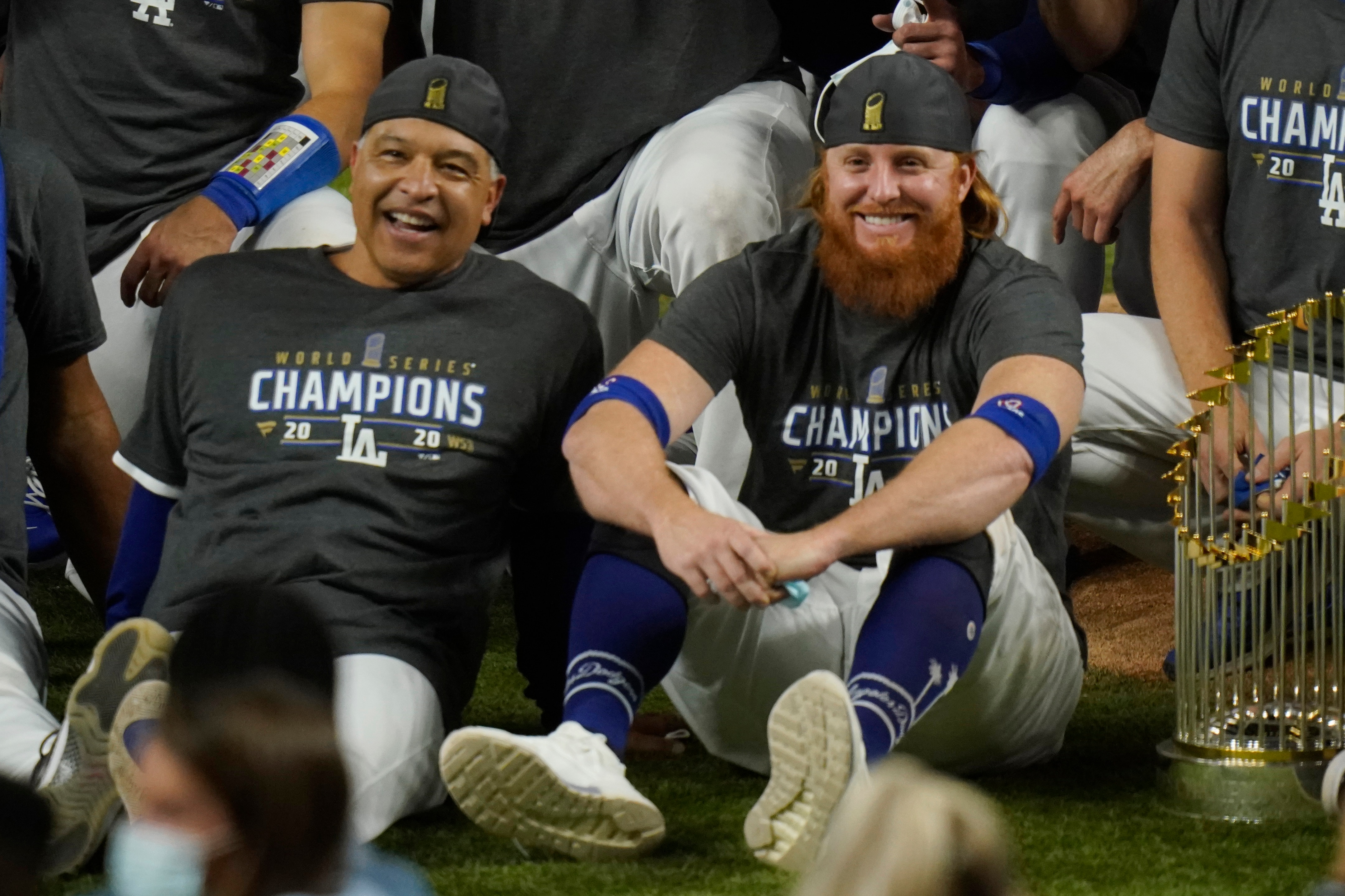 FILE - Los Angeles Dodgers manager Dave Roberts, left, and third baseman Justin Turner pose for a group picture after the Dodgers defeated the Tampa Bay Rays 3-1 in Game 6 to win the baseball World Series in Arlington, Texas, in this Tuesday, Oct. 27, 2020, file photo. Justin Turner's extended flirtation with free agency ended where it began â€” with the Los Angeles Dodgers. Along the way, the third baseman had doubts about whether he would return to his hometown team and wondered if his mask-less appearance on the field to celebrate its World Series championship would hurt him. (AP Photo/Eric Gay, File)