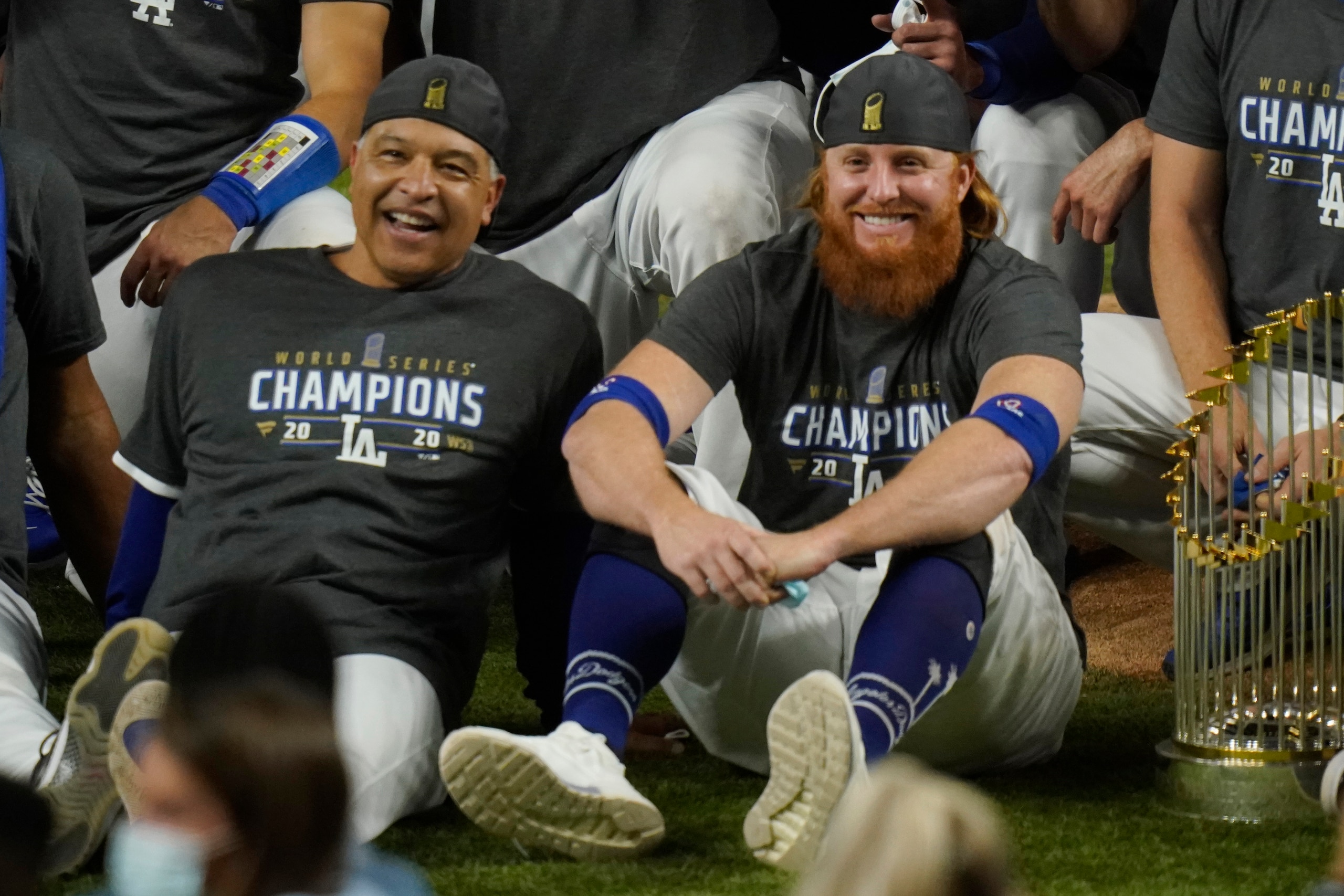 FILE - Los Angeles Dodgers manager Dave Roberts, left, and third baseman Justin Turner pose for a group picture after the Dodgers defeated the Tampa Bay Rays 3-1 in Game 6 to win the baseball World Series in Arlington, Texas, in this Tuesday, Oct. 27, 2020, file photo. Justin Turner's extended flirtation with free agency ended where it began â€” with the Los Angeles Dodgers. Along the way, the third baseman had doubts about whether he would return to his hometown team and wondered if his mask-less appearance on the field to celebrate its World Series championship would hurt him. (AP Photo/Eric Gay, File)