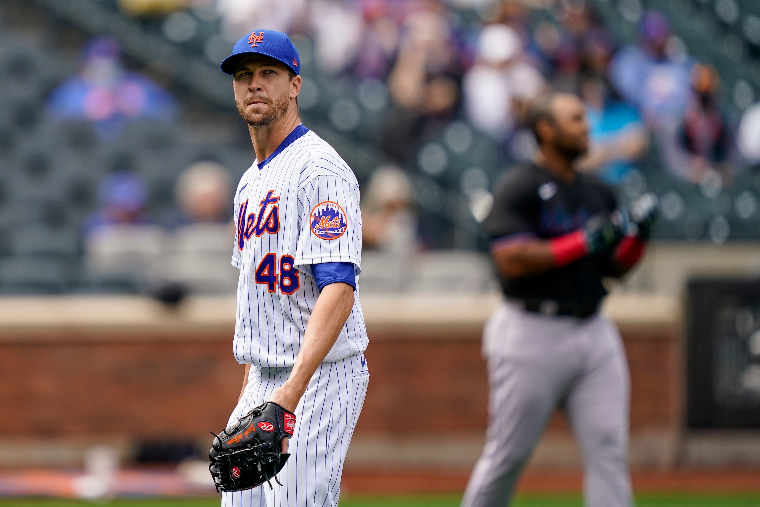 New York Mets starting pitcher Jacob deGrom (48) walks off the field after striking out Miami Marlins' Jesus Aguilar in the first inning of a baseball game, Saturday, April 10, 2021, in New York. (AP Photo/John Minchillo)