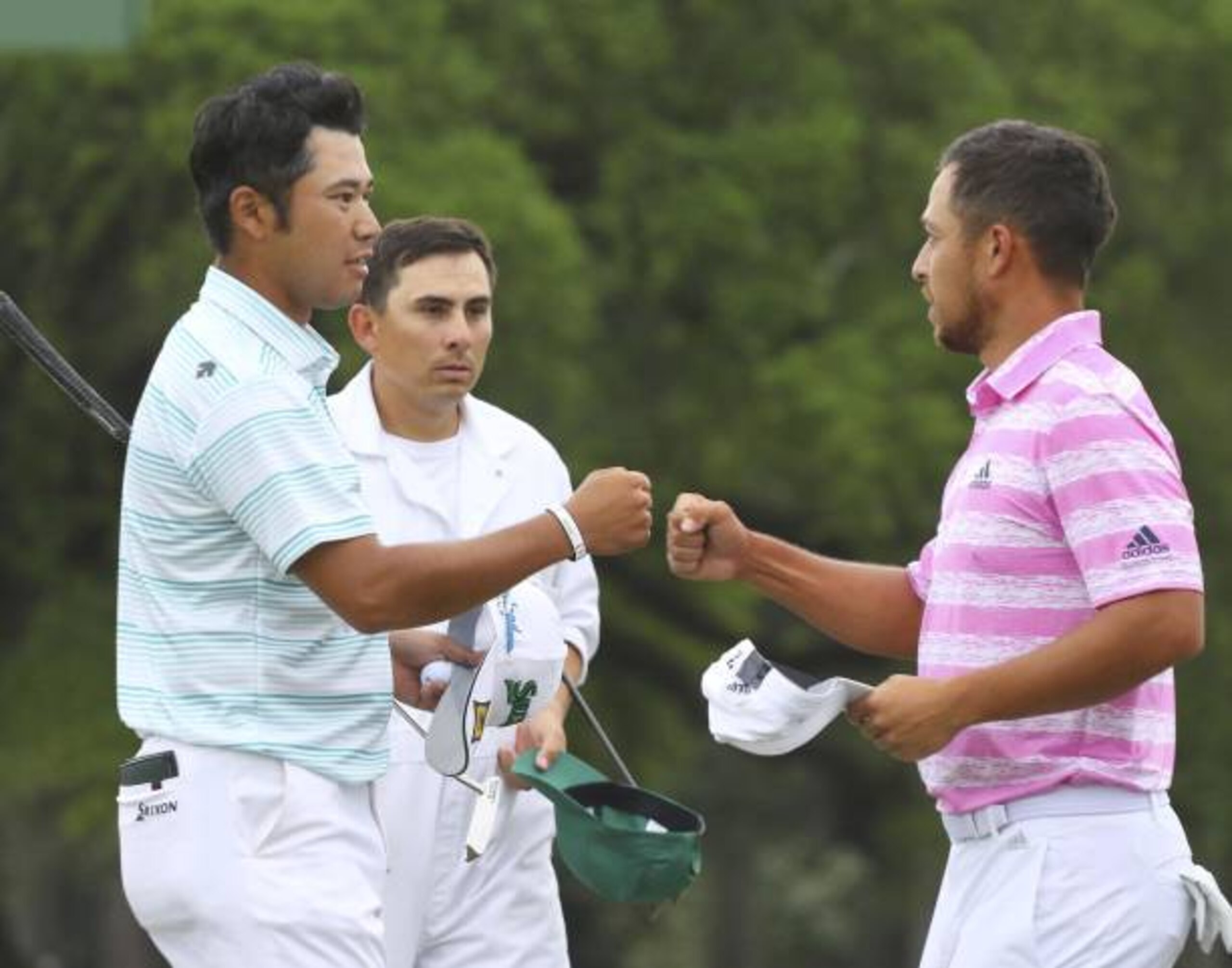 Japan's Hideki Matsuyama (L) and Xander Schauffele (R) of the United States fist bump after the third round of the Masters Tournament on April 10, 2021, at Augusta National Golf Club in Augusta, Georgia. (Photo by Kyodo News via Getty Images)