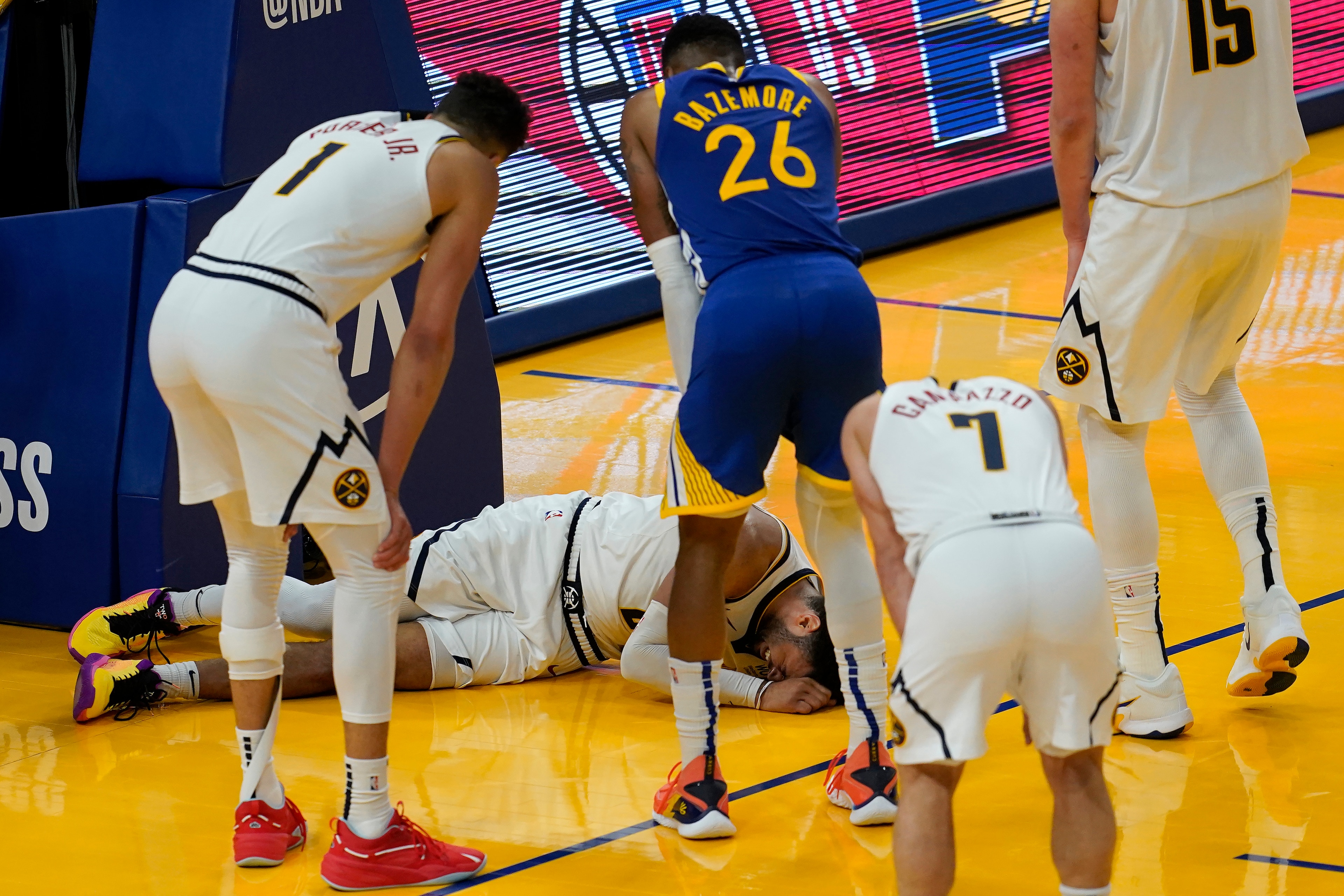 Players watch as Denver Nuggets guard Jamal Murray remains on the floor after being injured during the second half of an NBA basketball game against the Golden State Warriors in San Francisco, Monday, April 12, 2021. (AP Photo/Jeff Chiu) Players watch as Denver Nuggets guard Jamal Murray remains on the floor after being injured during the second half of an NBA basketball game against the Golden State Warriors in San Francisco, Monday, April 12, 2021. (AP Photo/Jeff Chiu)