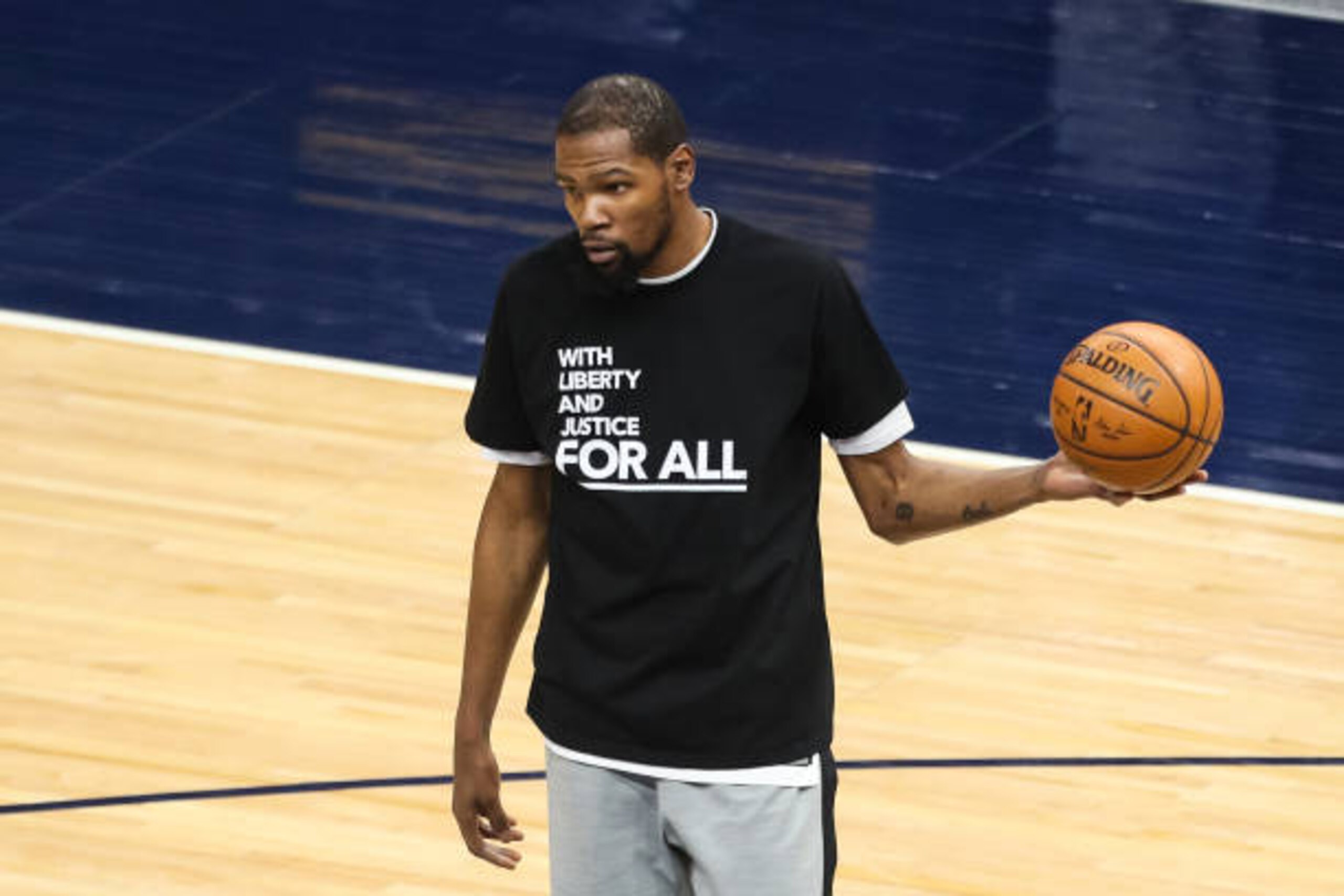 MINNEAPOLIS, MN - APRIL 13: Kevin Durant #7 of the Brooklyn Nets wears a shirt supporting social justice before the start of a game against the Minnesota Timberwolves at Target Center on April 13, 2021 in Minneapolis, Minnesota. Protests continue across the U.S. after 20-year-old Daunte Wright was recently killed by a Brooklyn Center, Minnesota police officer during a traffic stop. NOTE TO USER: User expressly acknowledges and agrees that, by downloading and or using this Photograph, user is consenting to the terms and conditions of the Getty Images License Agreement. (Photo by David Berding/Getty Images) MINNEAPOLIS, MN - APRIL 13: Kevin Durant #7 of the Brooklyn Nets wears a shirt supporting social justice before the start of a game against the Minnesota Timberwolves at Target Center on April 13, 2021 in Minneapolis, Minnesota. Protests continue across the U.S. after 20-year-old Daunte Wright was recently killed by a Brooklyn Center, Minnesota police officer during a traffic stop. NOTE TO USER: User expressly acknowledges and agrees that, by downloading and or using this Photograph, user is consenting to the terms and conditions of the Getty Images License Agreement. (Photo by David Berding/Getty Images)