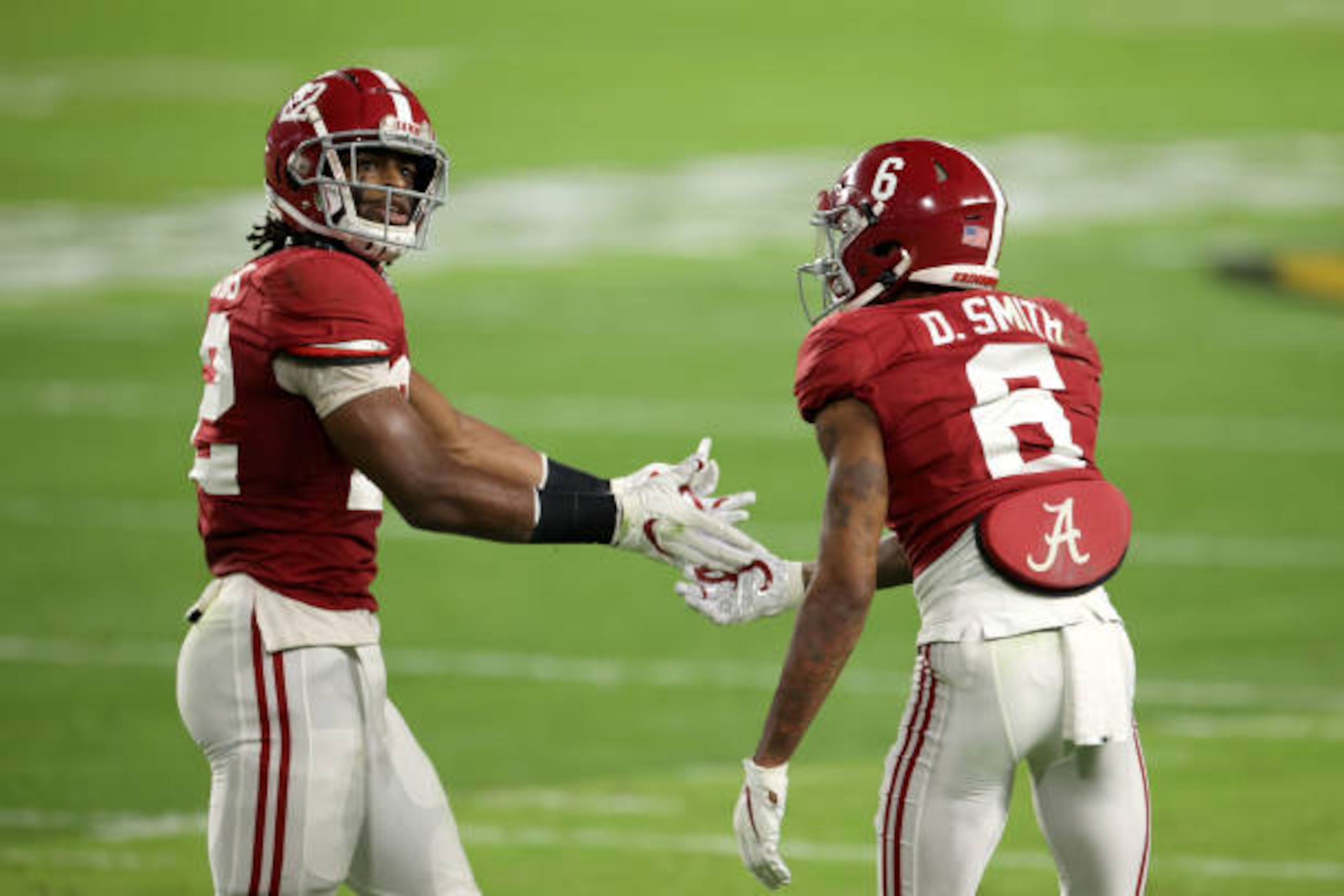 MIAMI GARDENS, FLORIDA - JANUARY 11: DeVonta Smith #6 and Najee Harris #22 of the Alabama Crimson Tide react to a play against the Alabama Crimson Tide during the first quarter of the College Football Playoff National Championship  at Hard Rock Stadium on January 11, 2021 in Miami Gardens, Florida. (Photo by Jamie Schwaberow/Getty Images)