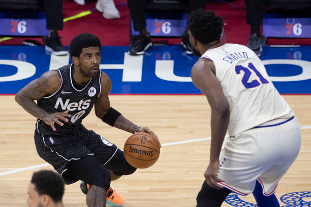 PHILADELPHIA, PA - APRIL 14: Kyrie Irving #11 of the Brooklyn Nets controls the ball against Joel Embiid #21 of the Philadelphia 76ers in the first quarter at the Wells Fargo Center on April 14, 2021 in Philadelphia, Pennsylvania. NOTE TO USER: User expressly acknowledges and agrees that, by downloading and or using this photograph, User is consenting to the terms and conditions of the Getty Images License Agreement. (Photo by Mitchell Leff/Getty Images)