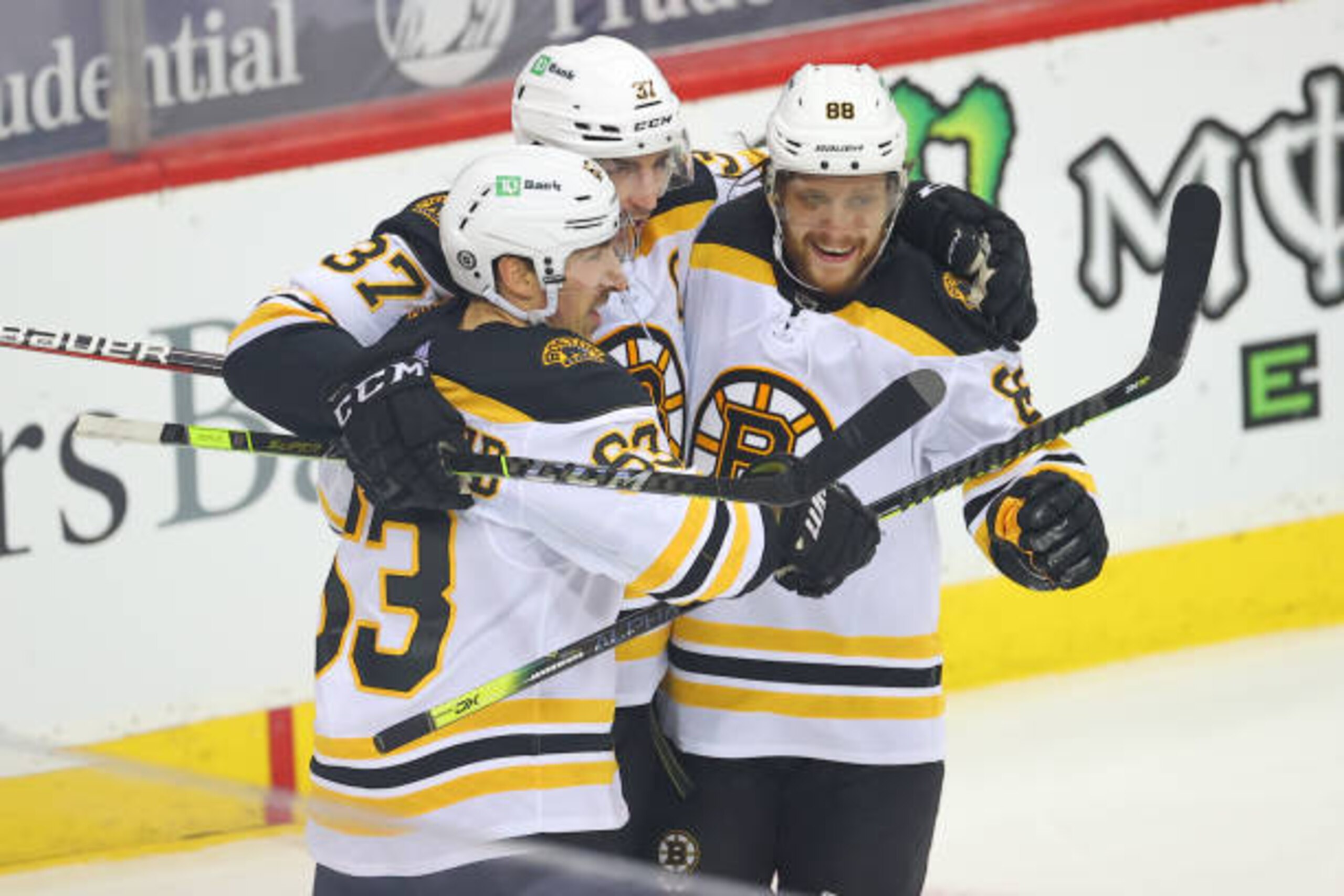NEWARK, NJ - MAY 03:  Boston Bruins center Patrice Bergeron (37) celebrates with teammates Boston Bruins center Brad Marchand (63) and Boston Bruins right wing David Pastrnak (88) after scoring during the second period of the  National Hockey League game between the New Jersey Devils and the Boston Bruins on May 3, 2021 at the Prudential Center in Newark, NJ.  (Photo by Rich Graessle/Icon Sportswire via Getty Images)