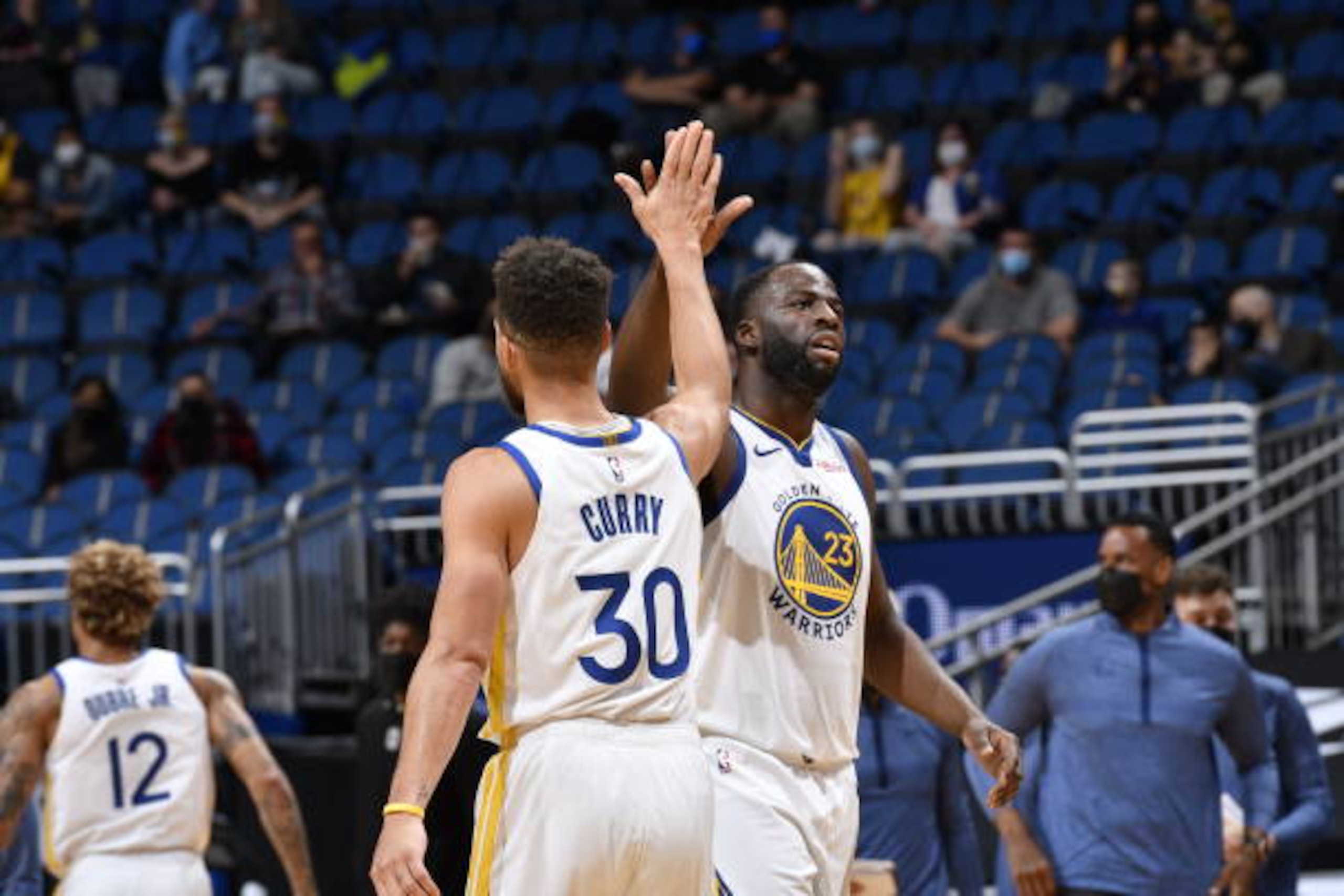ORLANDO, FL - FEBRUARY 19: Stephen Curry #30 and Draymond Green #23 of the Golden State Warriors hi-five during the game against the Orlando Magic on February 14, 2021 at Amway Center in Orlando, Florida. NOTE TO USER: User expressly acknowledges and agrees that, by downloading and or using this photograph, User is consenting to the terms and conditions of the Getty Images License Agreement. Mandatory Copyright Notice: Copyright 2021 NBAE (Photo by Fernando Medina/NBAE via Getty Images)
