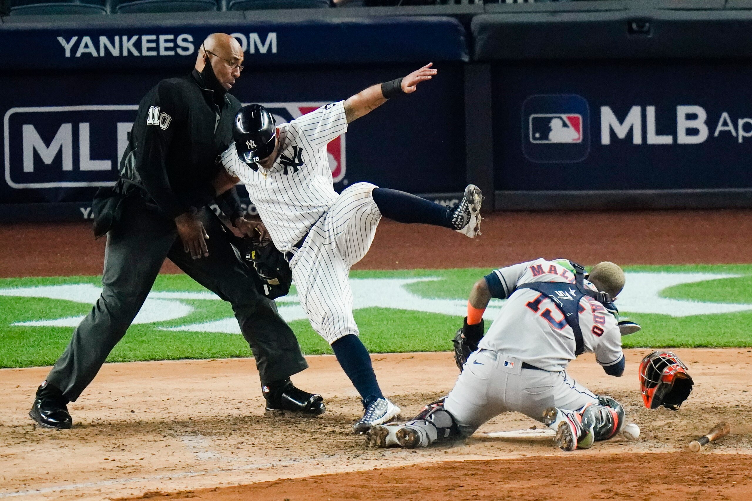 New York Yankees' Rougned Odor falls into the home plat umpire after running past Houston Astros catcher Martin Maldonado to score during the sixth inning of a baseball game Tuesday, May 4, 2021, in New York. (AP Photo/Frank Franklin II)