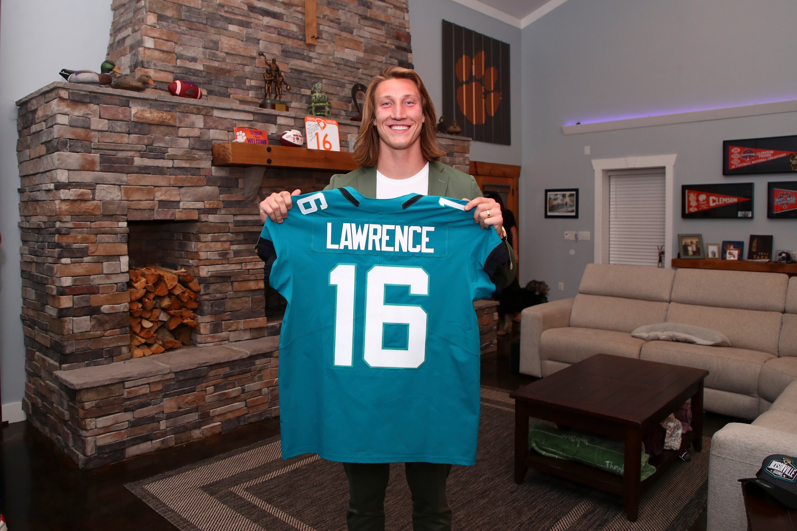 Clemson quarterback Trevor Lawrence holds up a jersey after being selected by the Jacksonville Jaguars with the first pick in the NFL football draft, Thursday, April 29, 2021, in Seneca, S.C. (Logan Bowles/NFL via AP) Clemson quarterback Trevor Lawrence holds up a jersey after being selected by the Jacksonville Jaguars with the first pick in the NFL football draft, Thursday, April 29, 2021, in Seneca, S.C. (Logan Bowles/NFL via AP)