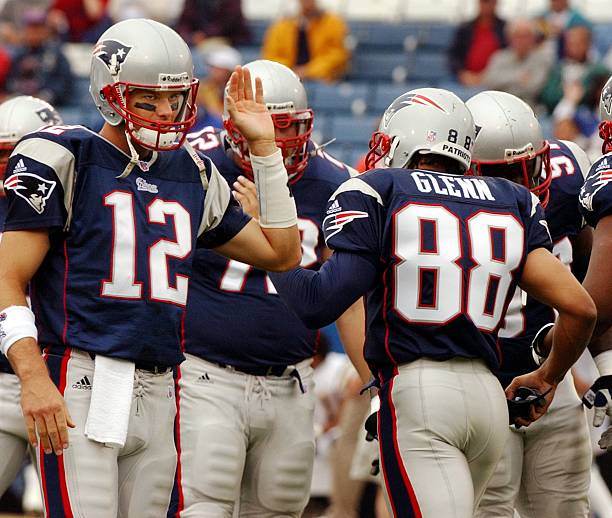 FOXBOROUGH, MA - OCTOBER 14: Patriots quarterback Tom Brady (left),was happy to see suspended wide receiver Terry Glenn (#88) as he comes onto the field, and gives him a high five prior to New England's 29-26 come from behind victory over the San Diego Chargers. He was probably more happy that he was back later in the afternoon, as the two teamed to help lead the home team to a win. (Photo by Jim Davis/The Boston Globe via Getty Images)