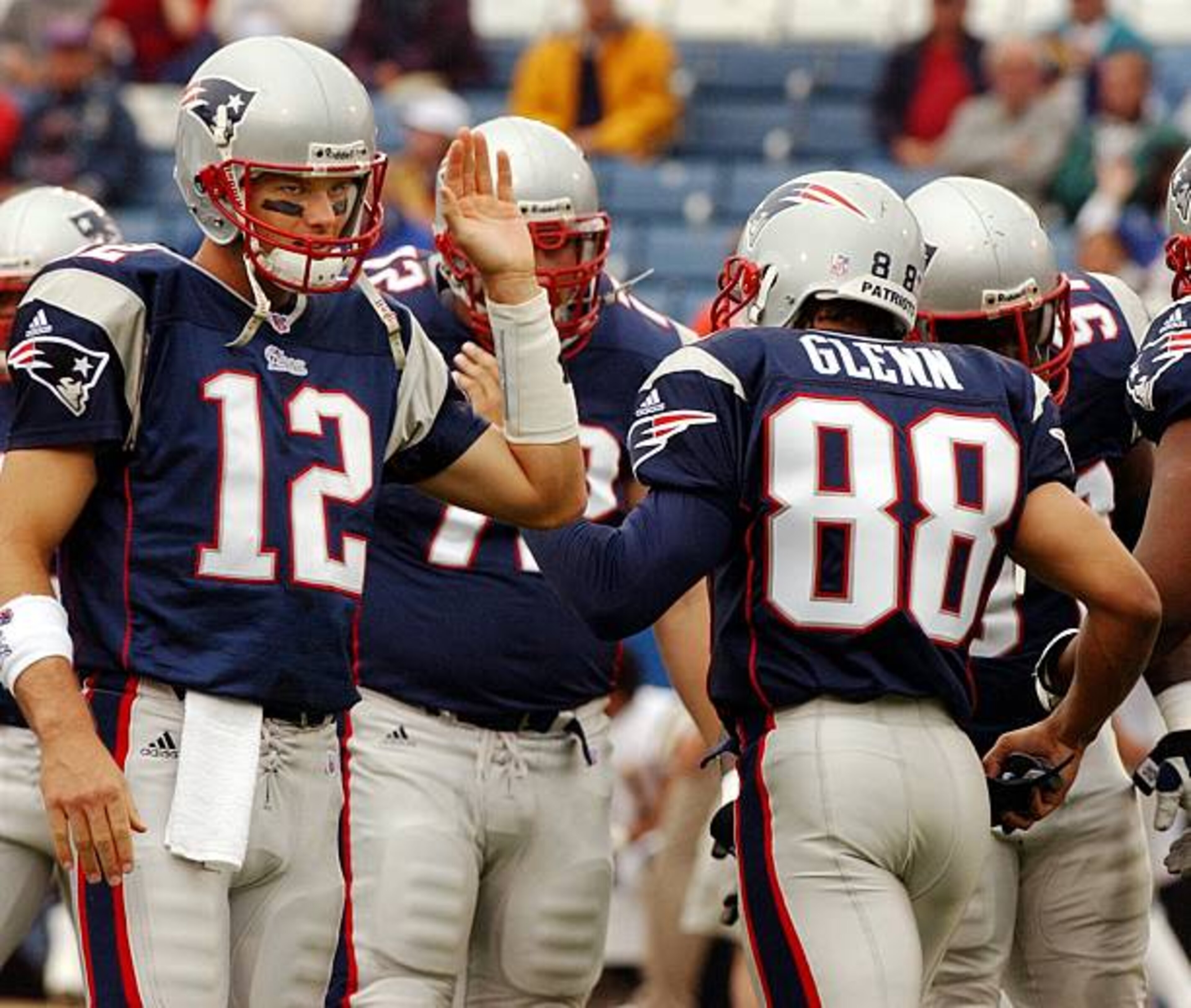 FOXBOROUGH, MA - OCTOBER 14: Patriots quarterback Tom Brady (left),was happy to see suspended wide receiver Terry Glenn (#88) as he comes onto the field, and gives him a high five prior to New England's 29-26 come from behind victory over the San Diego Chargers. He was probably more happy that he was back later in the afternoon, as the two teamed to help lead the home team to a win. (Photo by Jim Davis/The Boston Globe via Getty Images)