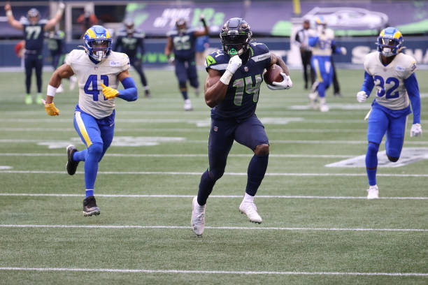 SEATTLE, WASHINGTON - JANUARY 09: Wide receiver DK Metcalf #14 of the Seattle Seahawks completes a reception over inside linebacker Kenny Young #41 of the Los Angeles Rams and carries for a touchdown during the second quarter of the NFC Wild Card Playoff game at Lumen Field on January 09, 2021 in Seattle, Washington. (Photo by Abbie Parr/Getty Images)