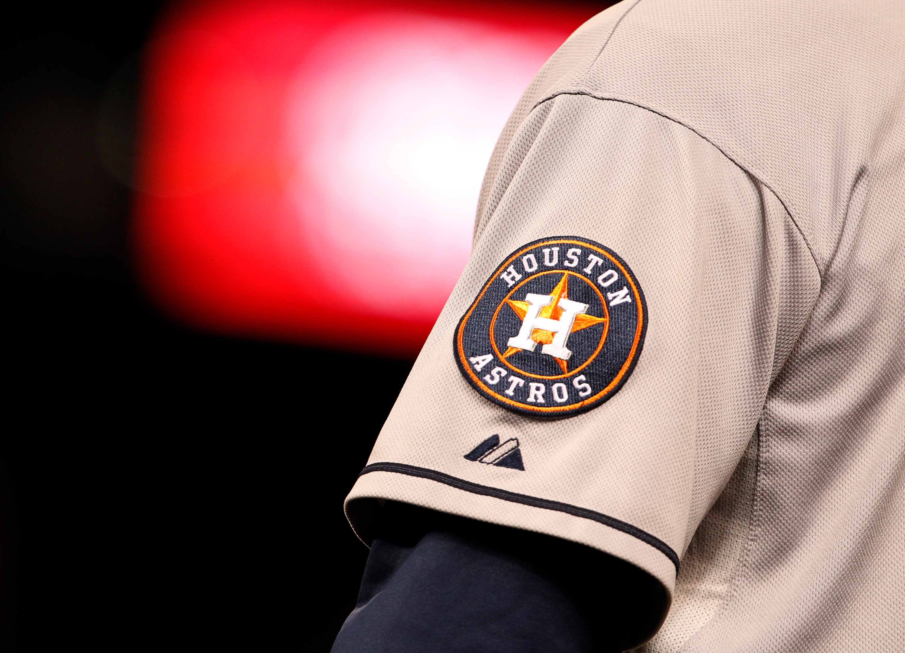 Houston Astros logo shines off sleeve of first base coach Dave Clark in the ninth inning of Astros' 6-3 victory over the Colorado Rockies in a baseball game in Denver on Wednesday, May 29, 2013. (AP Photo/David Zalubowski)