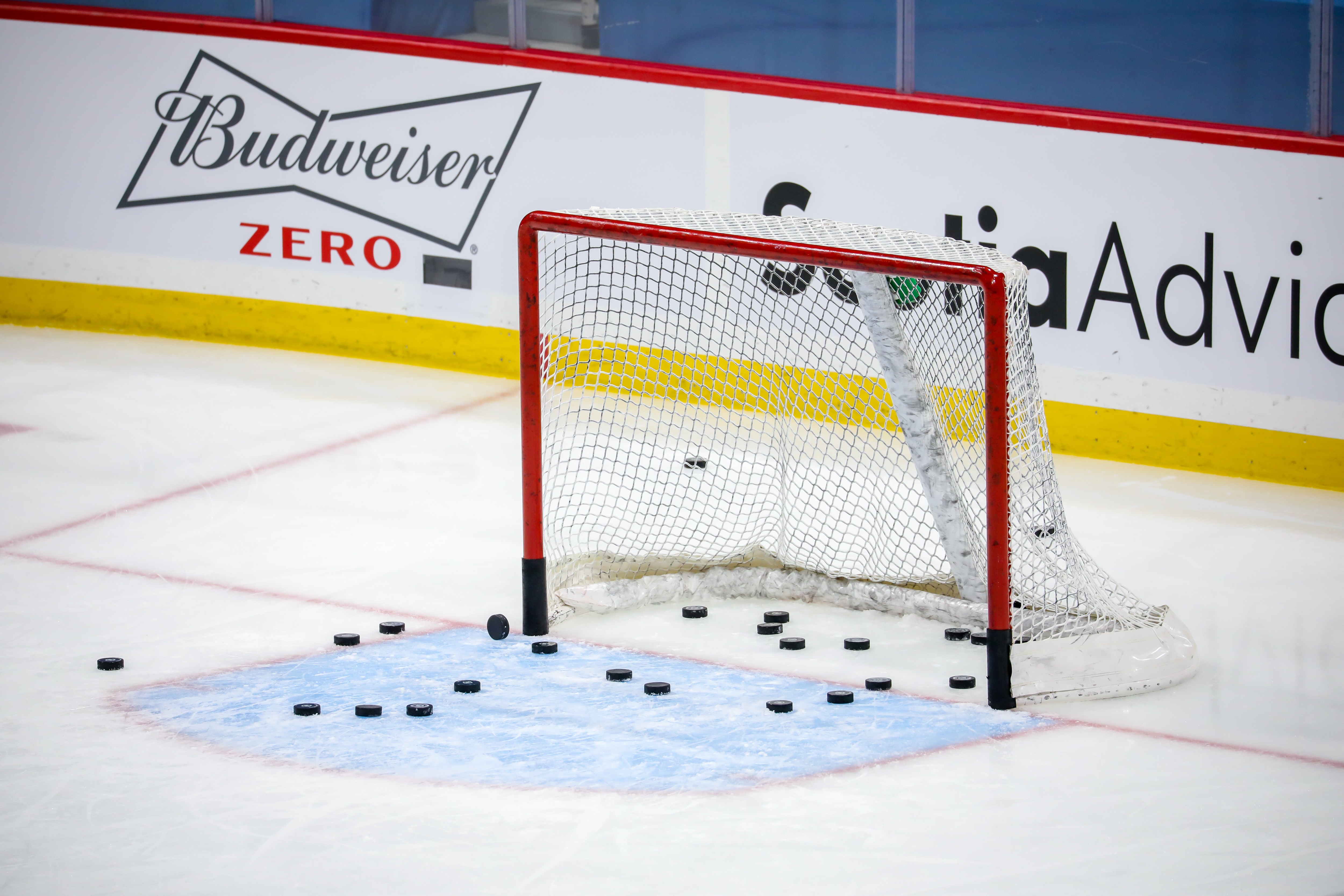 WINNIPEG, MB - FEBRUARY 02: Some hockey pucks sit in the empty net during the pre-game warm up prior to NHL action between the Calgary Flames and the Winnipeg Jets at Bell MTS Place on February 02, 2021 in Winnipeg, Manitoba. (Photo by Jonathan Kozub/NHLI via Getty Images)