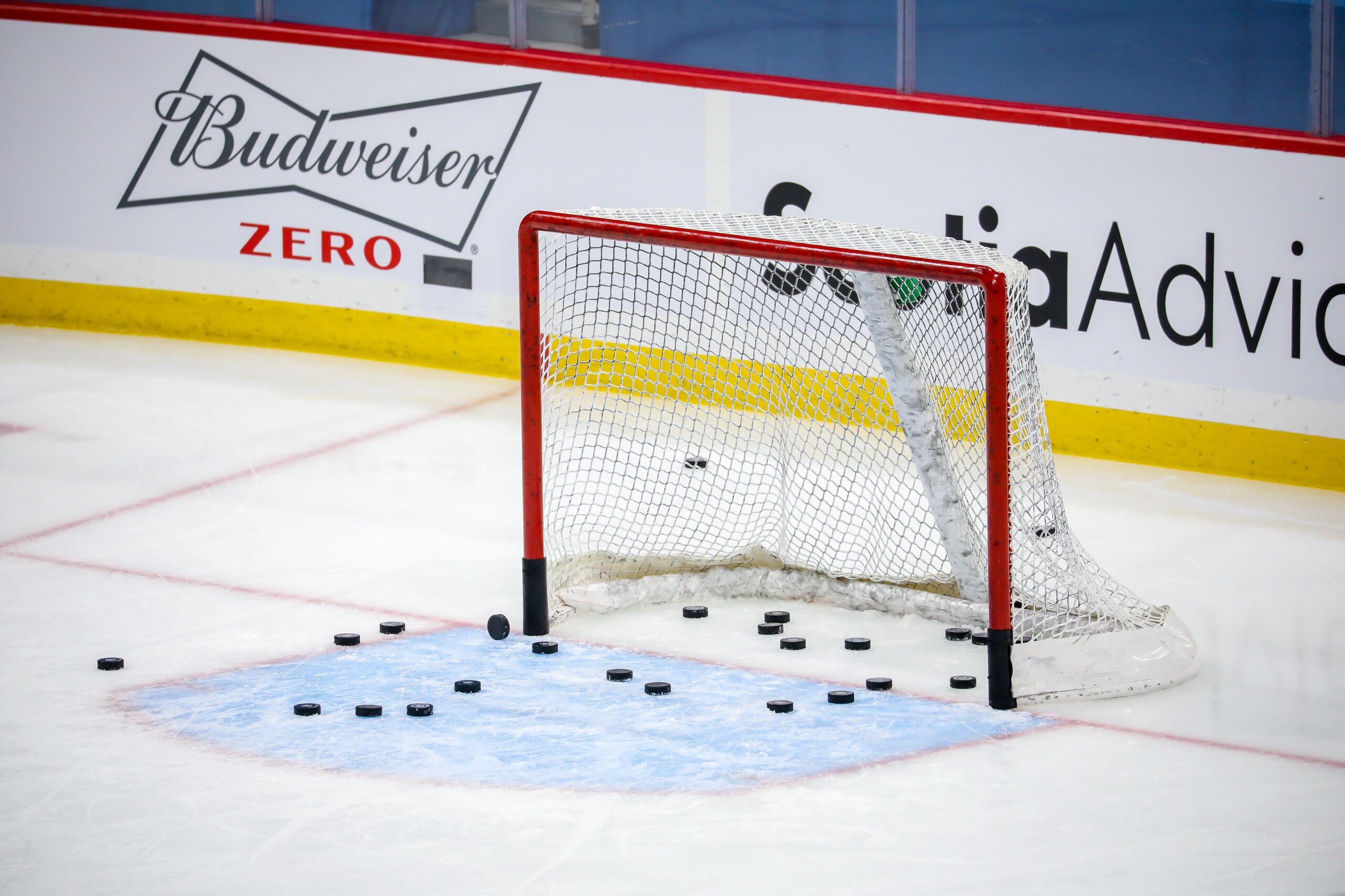 WINNIPEG, MB - FEBRUARY 02: Some hockey pucks sit in the empty net during the pre-game warm up prior to NHL action between the Calgary Flames and the Winnipeg Jets at Bell MTS Place on February 02, 2021 in Winnipeg, Manitoba. (Photo by Jonathan Kozub/NHLI via Getty Images)