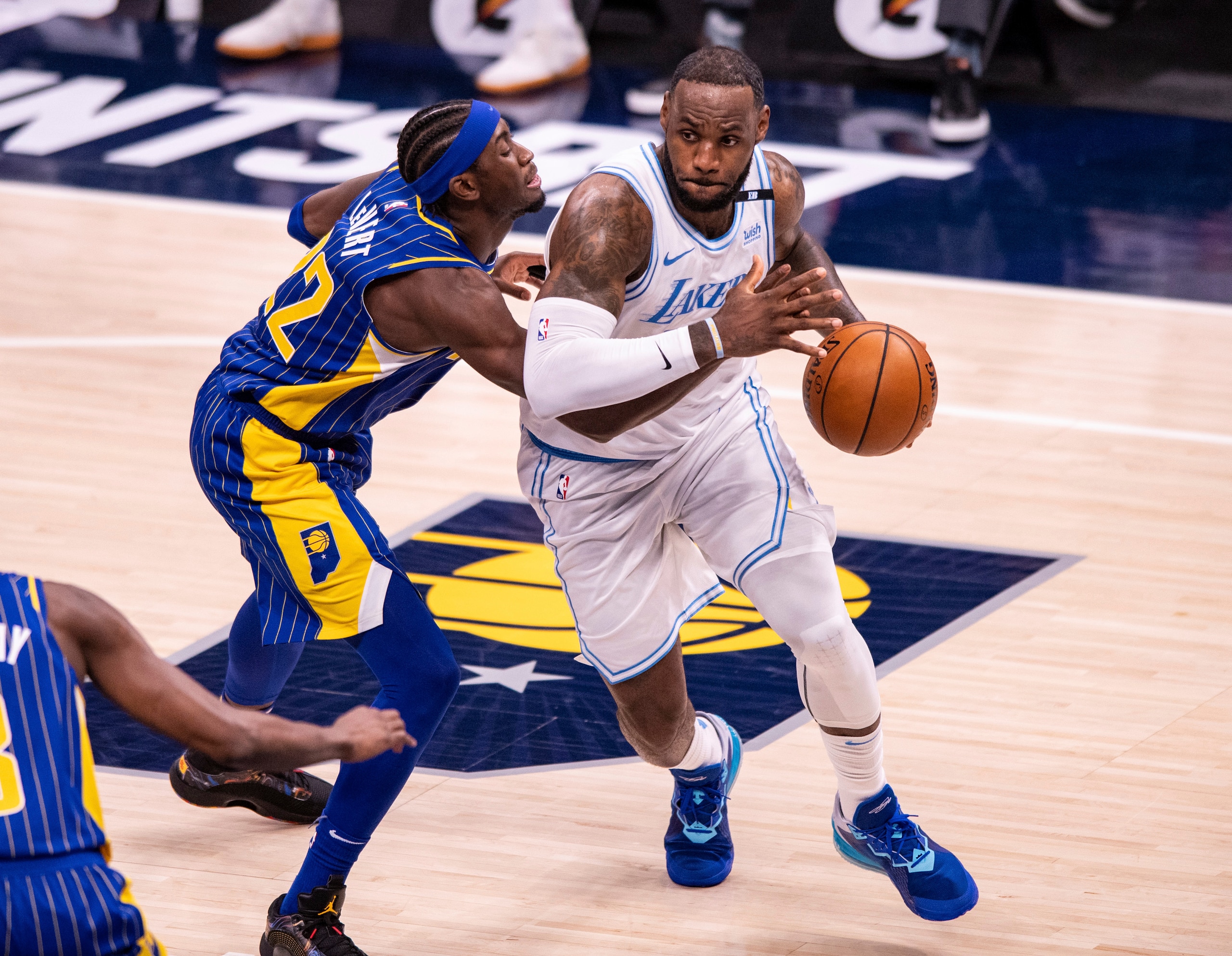 Indiana Pacers guard Caris LeVert (22) knocks the ball out of the hands of Los Angeles Lakers forward LeBron James (23) as he makes a move along the baseline during the first half of an NBA basketball game in Indianapolis, Saturday, May 15, 2021. (AP Photo/Doug McSchooler)