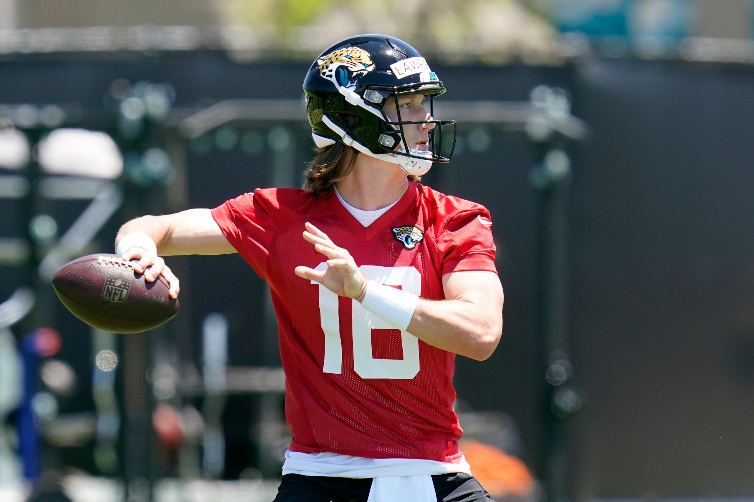 Jacksonville Jaguars quarterback Trevor Lawrence looks for a receiver during an NFL football rookie minicamp, Saturday, May 15, 2021, in Jacksonville, Fla. (AP Photo/John Raoux)