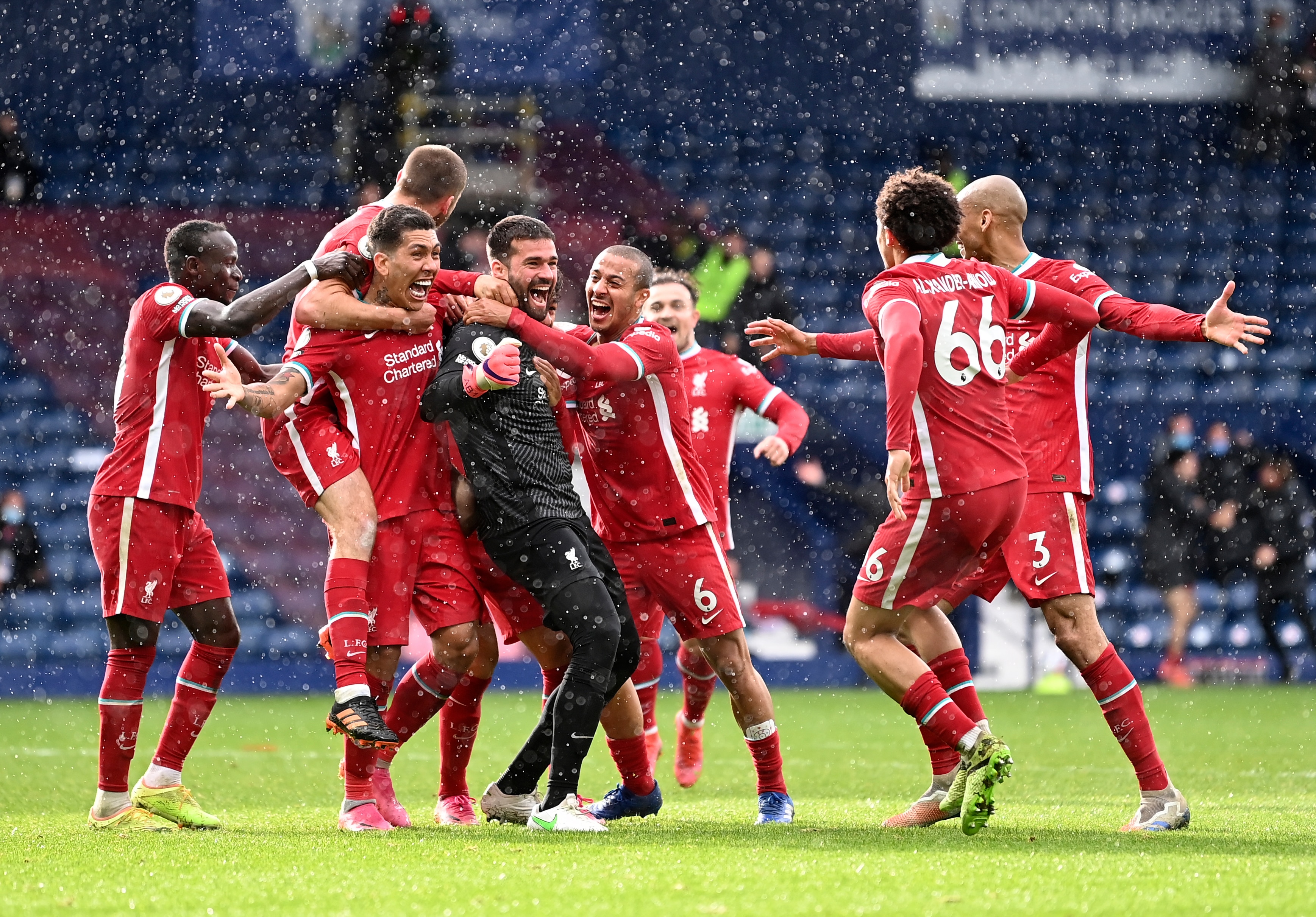 Liverpool's goalkeeper Alisson celebrates with teammates after scoring his side's second goal during the English Premier League soccer match between West Bromwich Albion and Liverpool at the Hawthorns stadium in West Bromwich, England, Sunday, May 16, 2021. (Laurence Griffiths/Pool via AP)