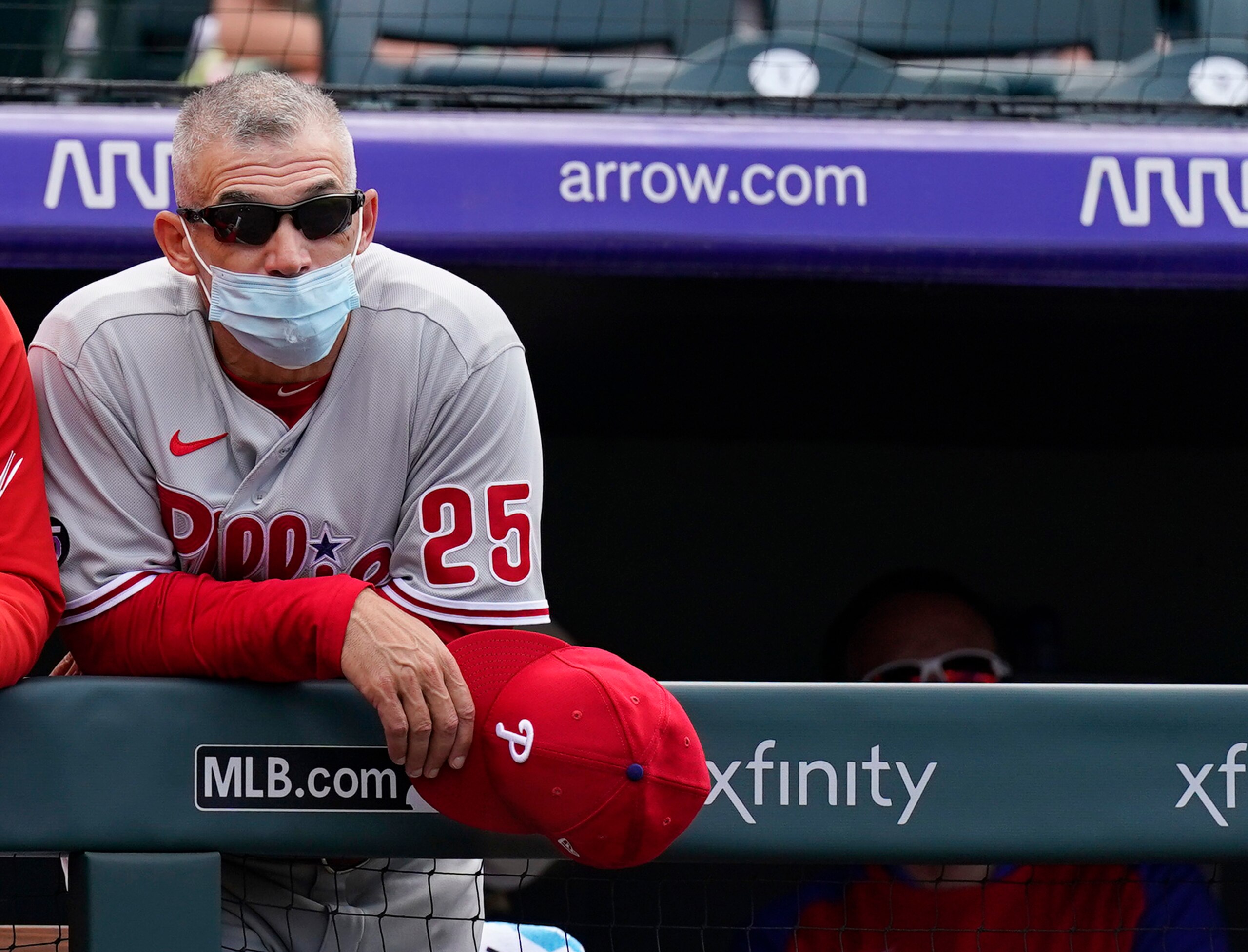 Philadelphia Phillies manager Joe Girardi leans on the dugout rail to watch Brad Miller commit the final out in the ninth inning of a baseball game against the Colorado Rockies Sunday, April 25, 2021, in Denver. Colorado won 12-2. (AP Photo/David Zalubowski)