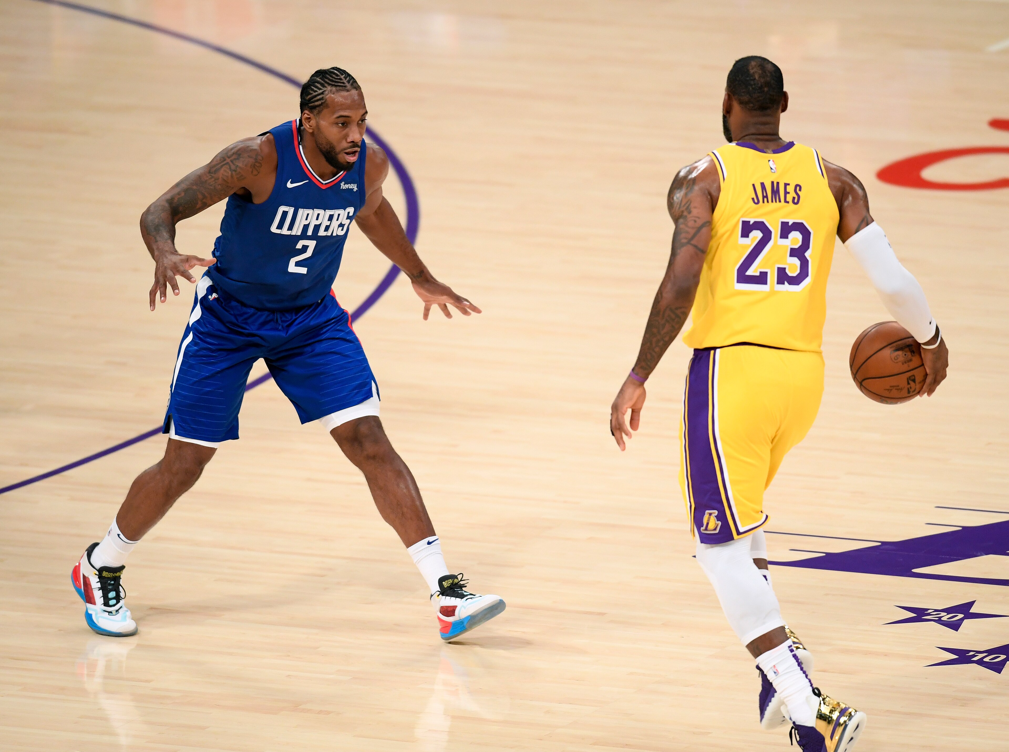 LOS ANGELES, CALIFORNIA - DECEMBER 22:  Kawhi Leonard #2 of the LA Clippers guards LeBron James #23 of the Los Angeles Lakers during the season opening game at Staples Center on December 22, 2020 in Los Angeles, California. NOTE TO USER: User expressly acknowledges and agrees that, by downloading and or using this photograph, User is consenting to the terms and conditions of the Getty Images License Agreement. (Photo by Harry How/Getty Images)
