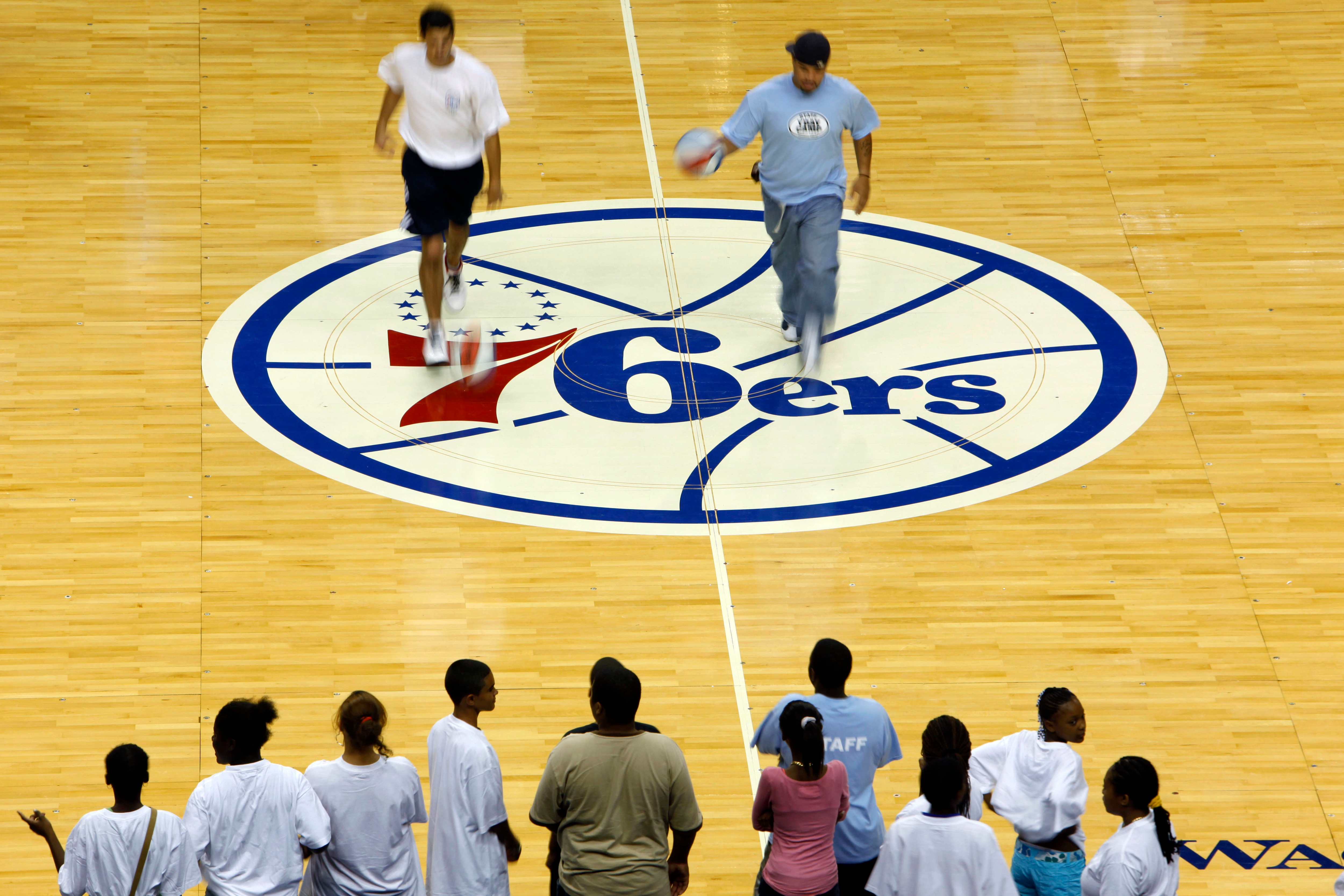 Dribbling exercises are demonstrate on the newly designed Philadelphia 76ers basketball court for the upcoming 2009-10 season, during the Summer Hoops Tour basketball clinic, in Philadelphia, Monday, Aug. 10, 2009.  The logo was last used in the 1996-97 season. (AP Photo/Matt Rourke)