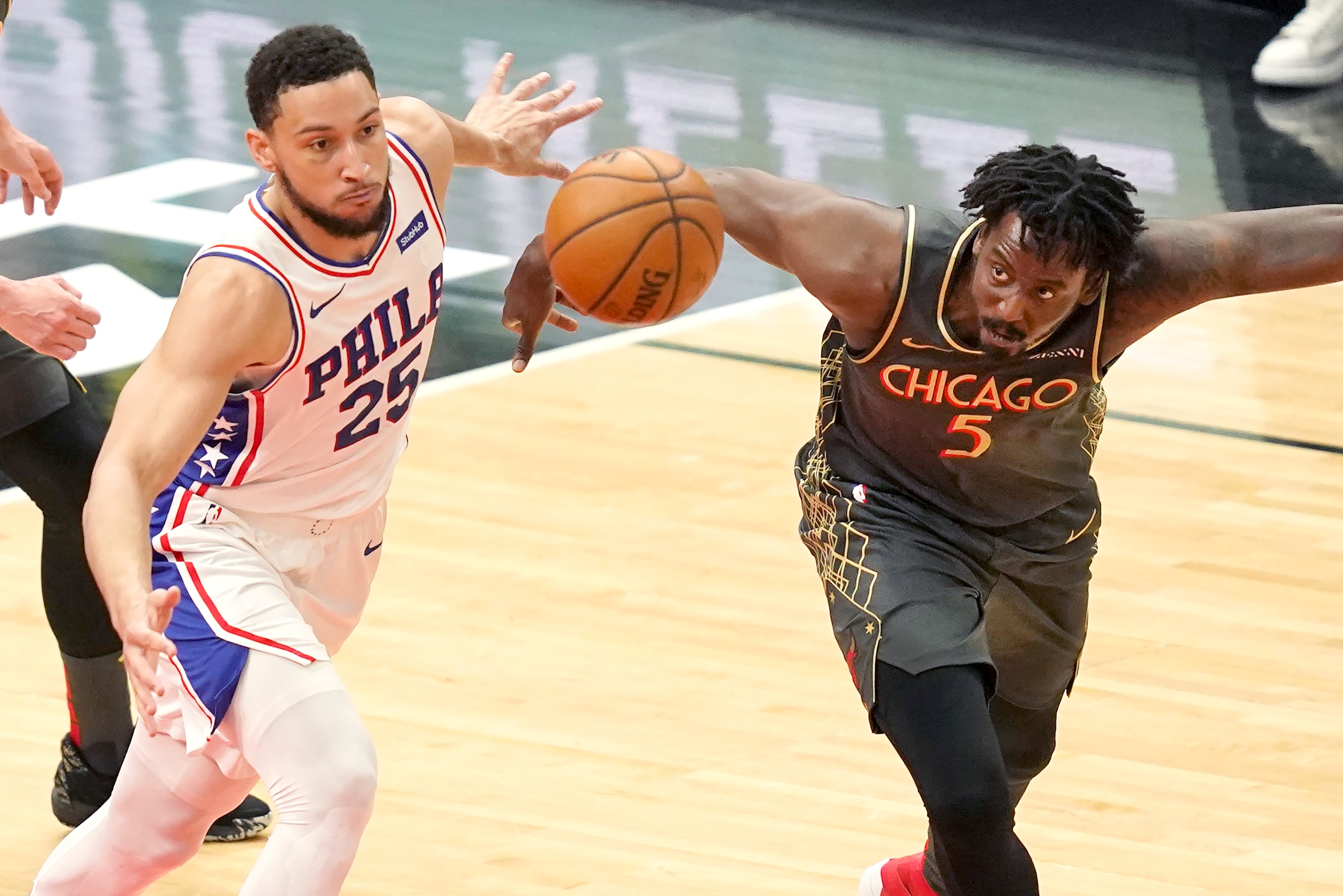Philadelphia 76ers' Ben Simmons, left, and Chicago Bulls' Al-Farouq Aminu, right, keep their eyes on a loose ball during the first half of an NBA basketball game Monday, May 3, 2021, in Chicago. (AP Photo/Charles Rex Arbogast)