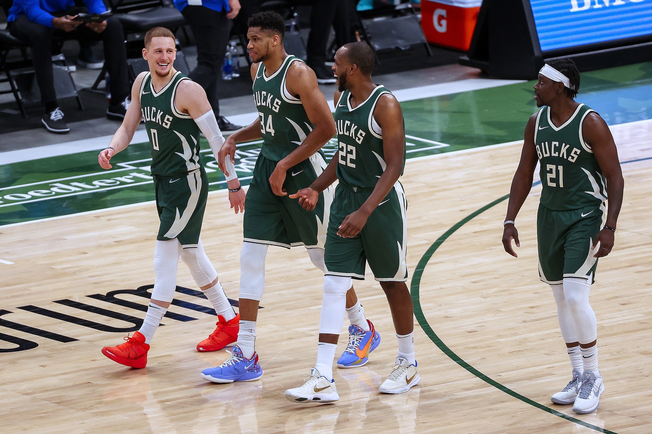 MILWAUKEE, WISCONSIN - MARCH 20: Donte DiVincenzo #0, Giannis Antetokounmpo #34, Khris Middleton #22, and Jrue Holiday #21 of the Milwaukee Bucks walk across the court in the third quarter against the San Antonio Spurs at the Fiserv Forum on March 20, 2021 in Milwaukee, Wisconsin. NOTE TO USER: User expressly acknowledges and agrees that, by downloading and or using this photograph, User is consenting to the terms and conditions of the Getty Images License Agreement. (Photo by Dylan Buell/Getty Images)