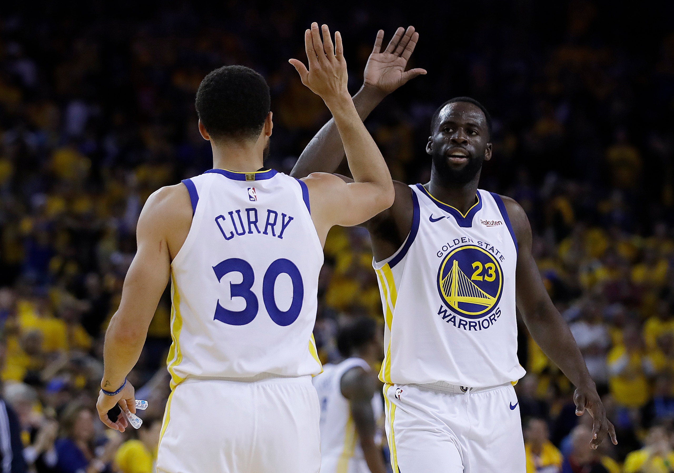 Golden State Warriors' Draymond Green, right, celebrates with Stephen Curry (30) during the final minutes of Game 1 of the team's NBA basketball playoffs Western Conference finals against the Portland Trail Blazers on Tuesday, May 14, 2019, in Oakland, Calif. (AP Photo/Ben Margot)