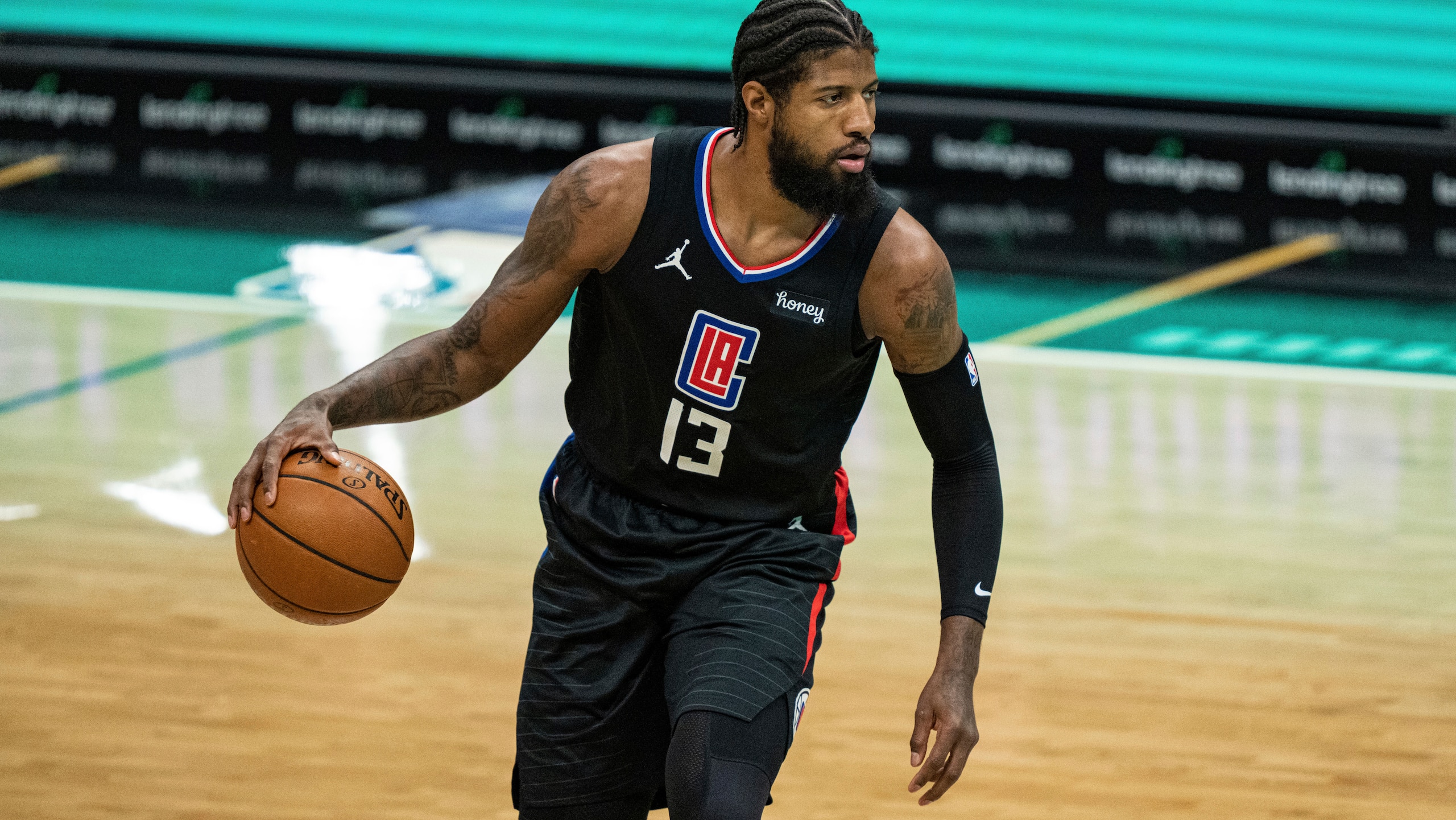 Los Angeles Clippers guard Paul George (13) brings the ball up court against the Charlotte Hornets during an NBA basketball game in Charlotte, N.C., Thursday, May 13, 2021. (AP Photo/Jacob Kupferman)