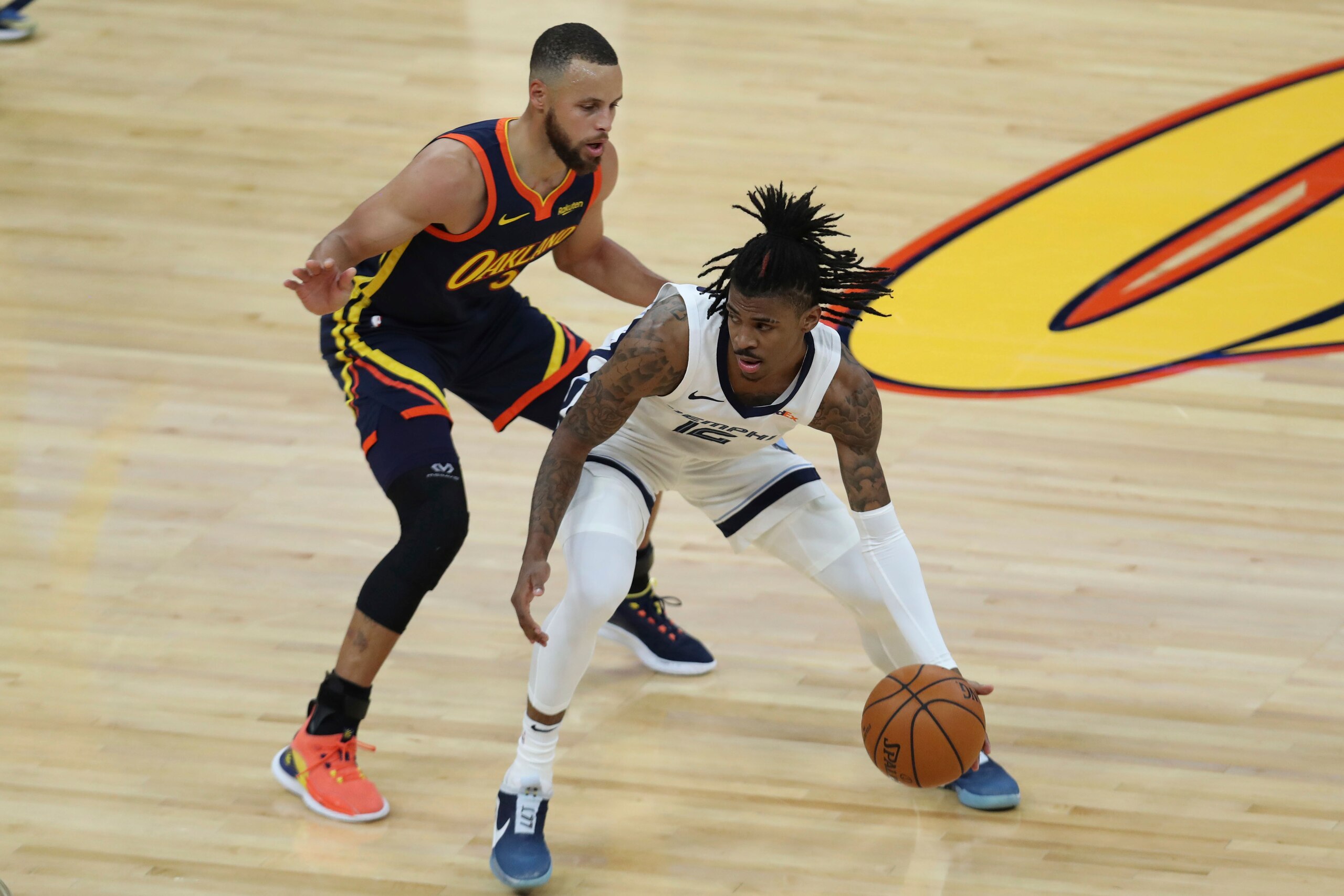 Memphis Grizzlies' Ja Morant, right, drives against Golden State Warriors' Stephen Curry during the first half of an NBA basketball Western Conference play-in game in San Francisco, Friday, May 21, 2021. (AP Photo/Jed Jacobsohn)