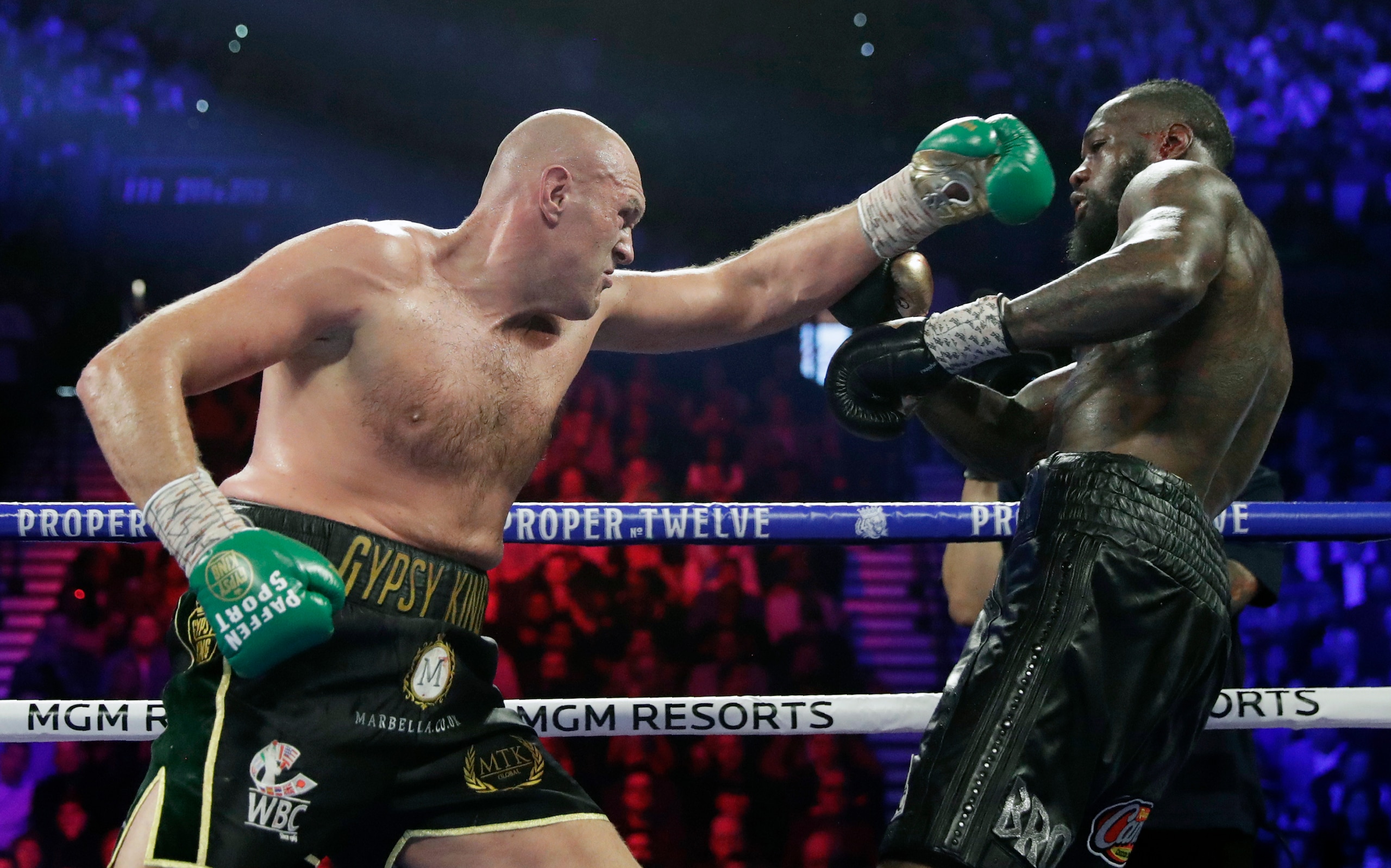 FILE - In this Feb. 22, 2020, file photo, Tyson Fury, left, of England, fights Deontay Wilder during a WBC heavyweight championship boxing match in Las Vegas. An all-British world heavyweight title showdown between Anthony Joshua and Tyson Fury in 2021 is a step closer. Fury said Wednesday, June 10, 2020, that an agreement has been reached with Joshua's camp on a two-fight deal between the current holders of the heavyweight belts.(AP Photo/Isaac Brekken, File)