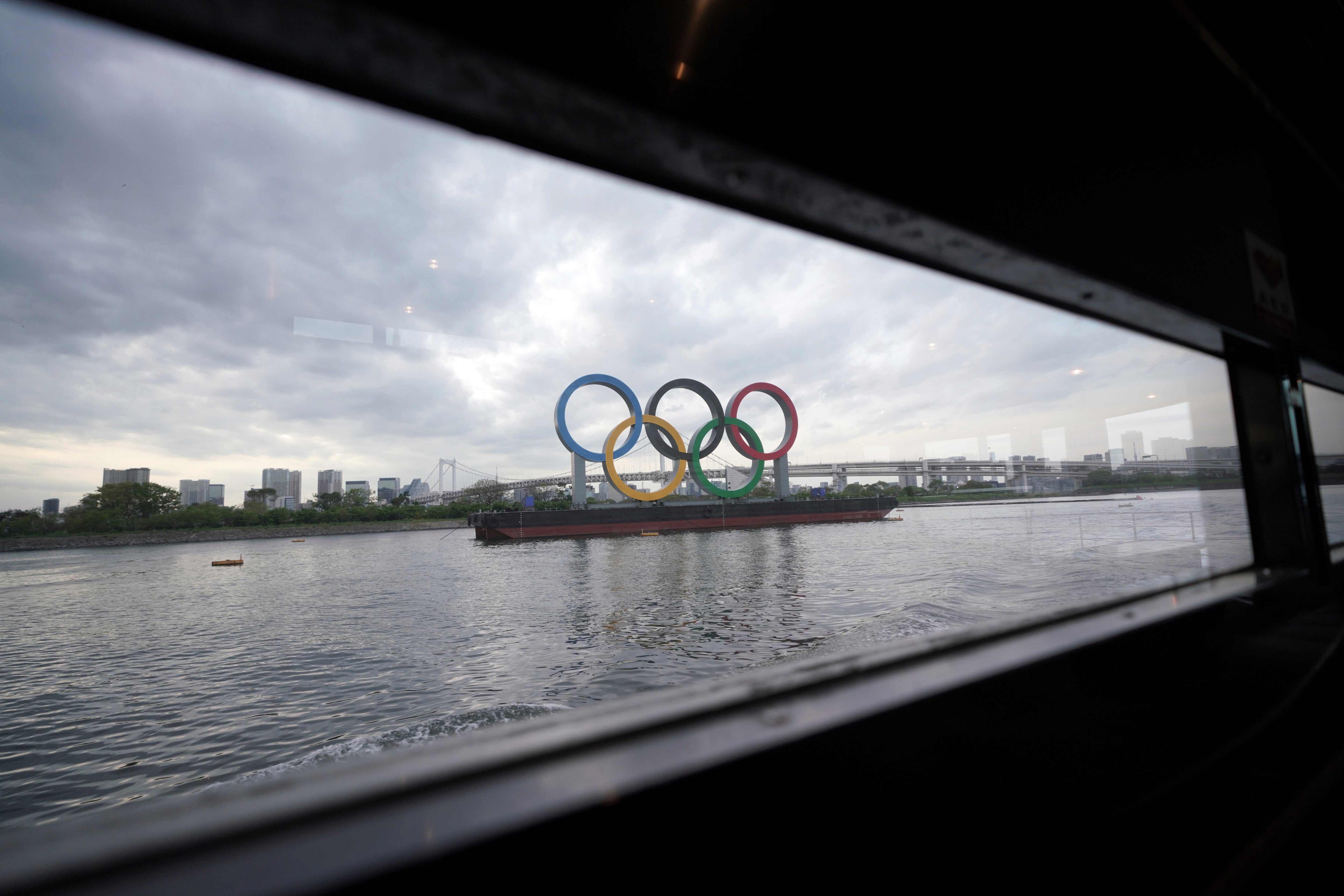 The Olympic rings floating in the water in the Odaiba section is seen from a window of a water bus Monday, April 12, 2021, in Tokyo. (AP Photo/Eugene Hoshiko)