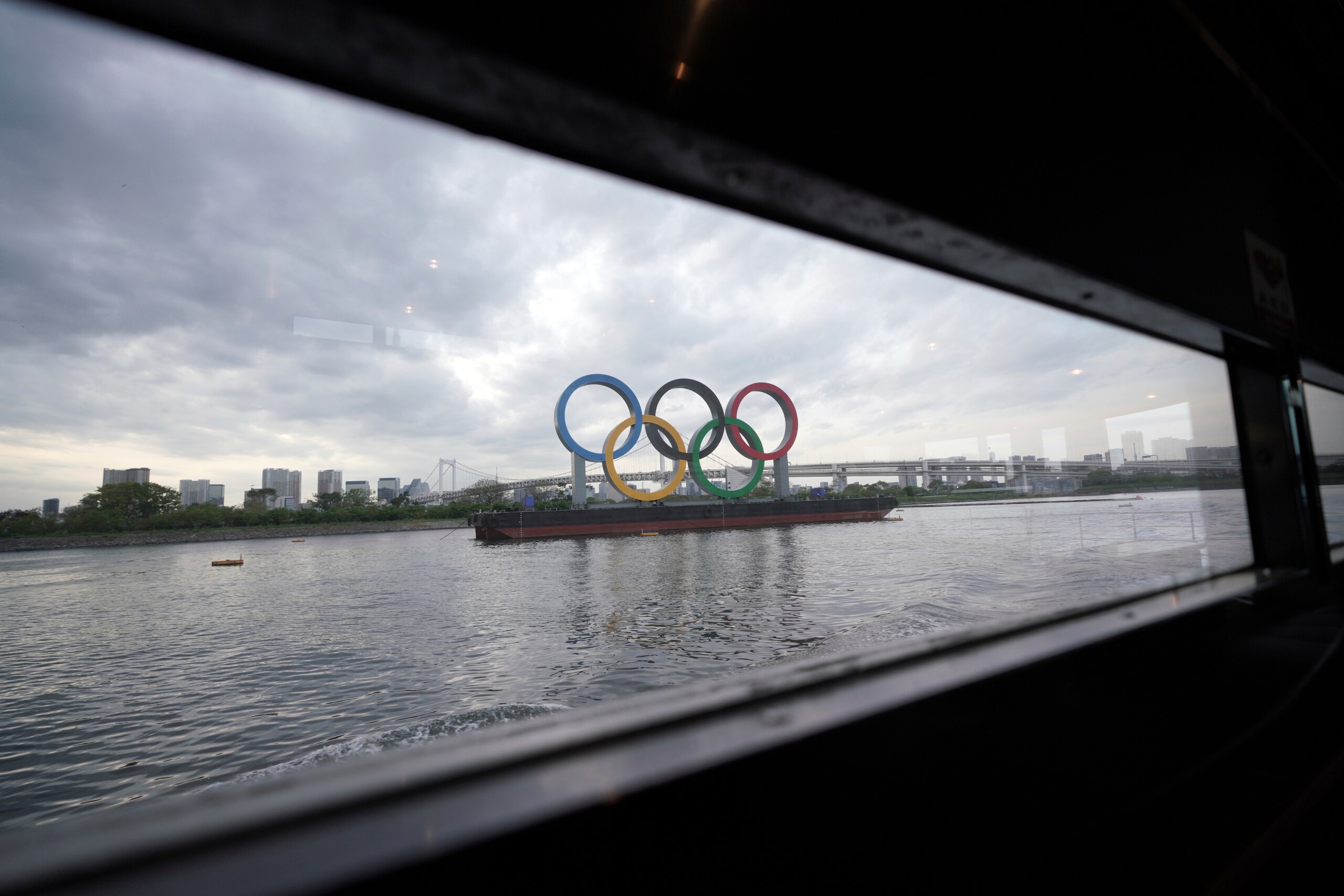 The Olympic rings floating in the water in the Odaiba section is seen from a window of a water bus Monday, April 12, 2021, in Tokyo. (AP Photo/Eugene Hoshiko)