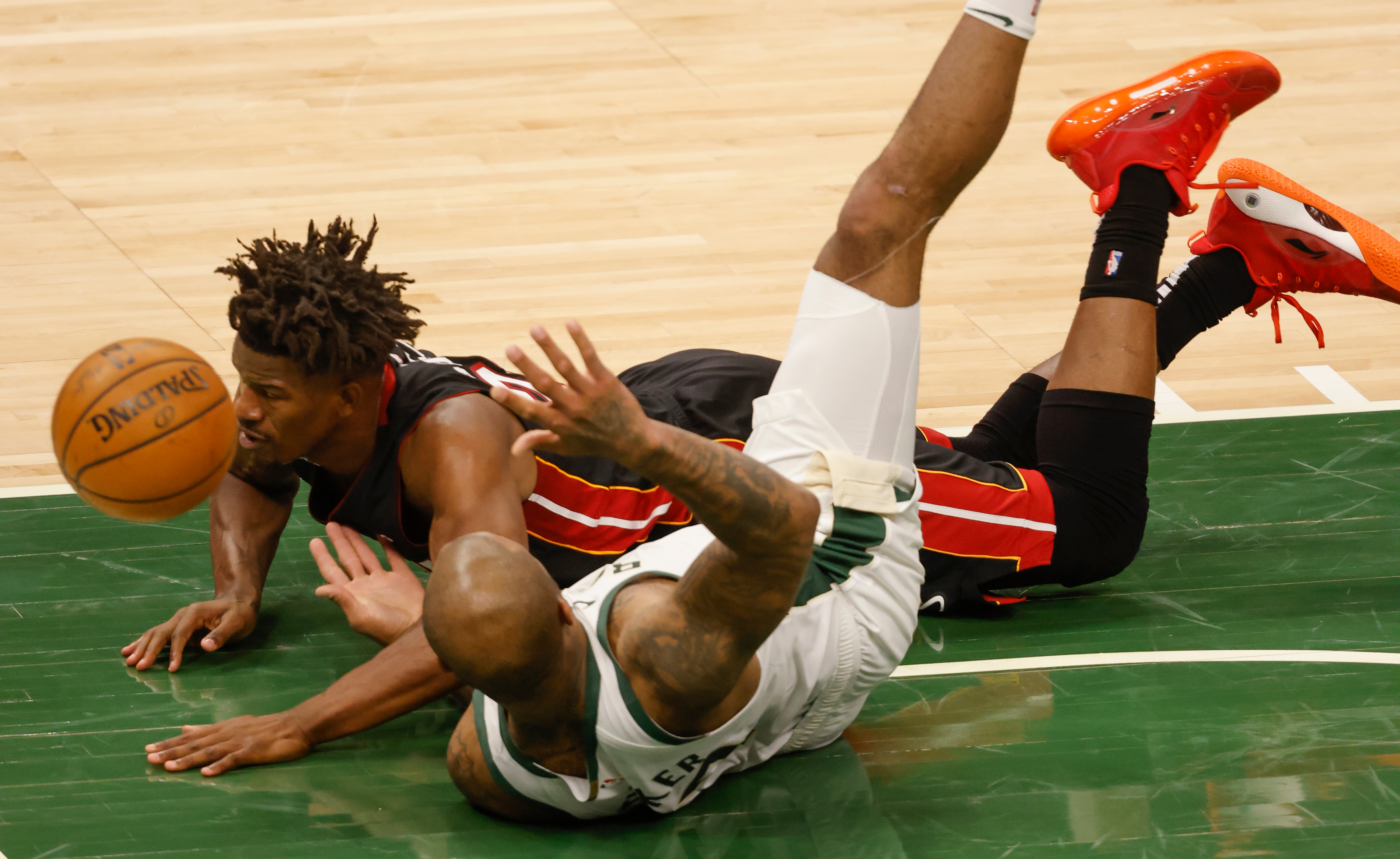 Miami Heat forward Jimmy Butler (22) falls to the floor against the Milwaukee Bucks during the first half of Game 2 of an NBA basketball first-round playoff series Monday, May 24, 2021, in Milwaukee. (AP Photo/Jeffrey Phelps)