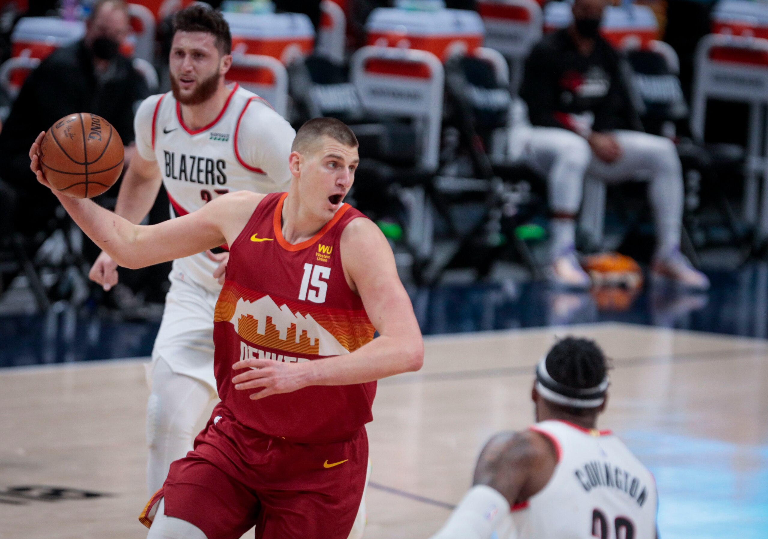 Denver Nuggets center Nikola Jokic (15) passes against Portland Trail Blazers forward Robert Covington (23) in the first quarter of Game 2 of a first-round NBA basketball playoff series Monday, May 24, 2021, in Denver. (AP Photo/Joe Mahoney)