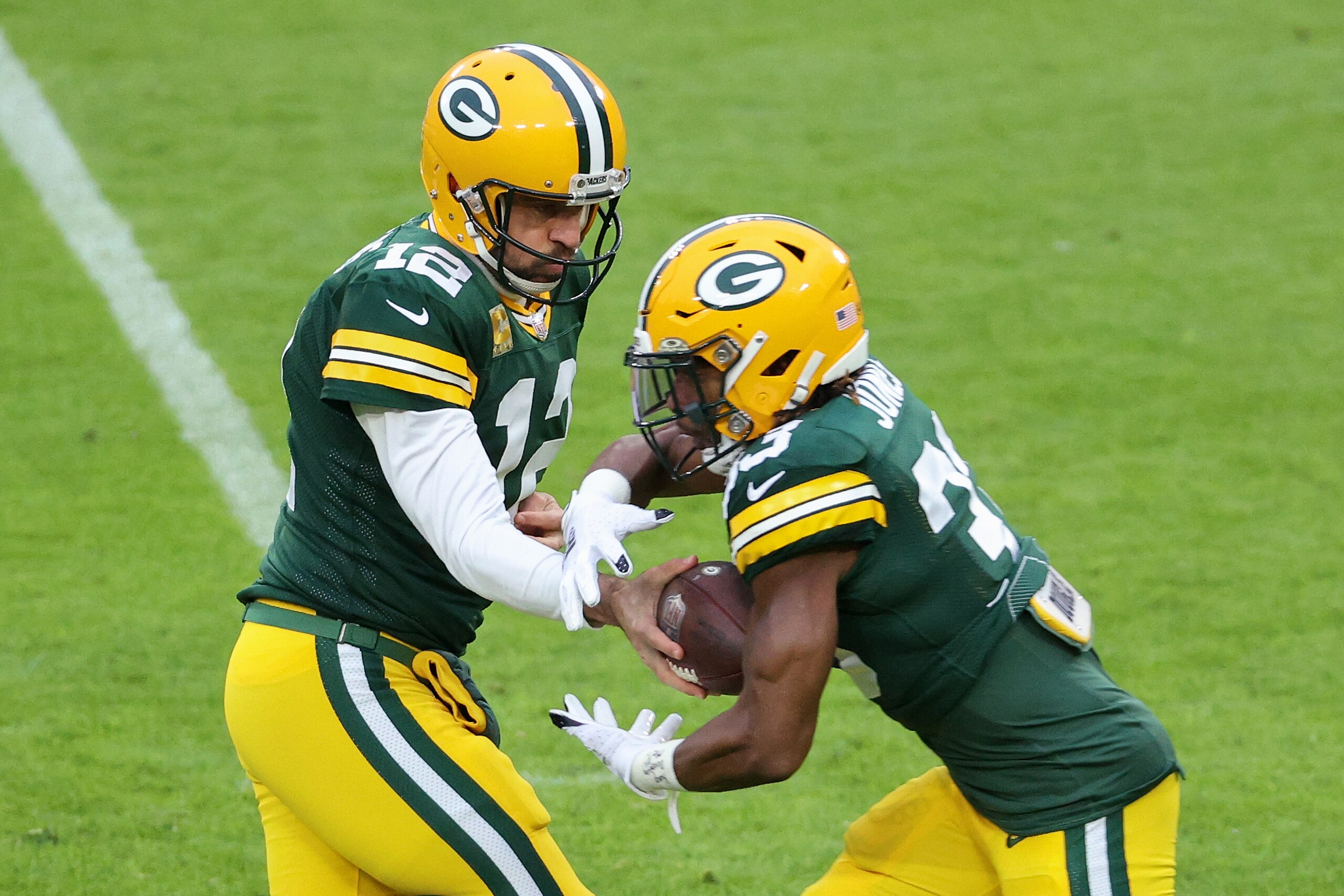 GREEN BAY, WISCONSIN - NOVEMBER 15: Aaron Rodgers #12 of the Green Bay Packers hands the ball off to Aaron Jones #33 in the first quarter against the Jacksonville Jaguars at Lambeau Field on November 15, 2020 in Green Bay, Wisconsin. (Photo by Dylan Buell/Getty Images) GREEN BAY, WISCONSIN - NOVEMBER 15: Aaron Rodgers #12 of the Green Bay Packers hands the ball off to Aaron Jones #33 in the first quarter against the Jacksonville Jaguars at Lambeau Field on November 15, 2020 in Green Bay, Wisconsin. (Photo by Dylan Buell/Getty Images)