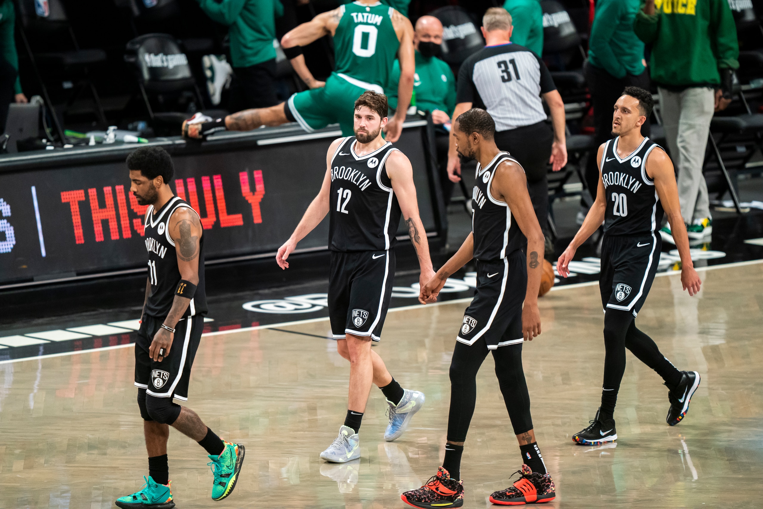 Brooklyn Nets guard Kyrie Irving (11), Joe Harris (12), forward Kevin Durant and guard Landry Shamet (20) walk to the bench during the second half of Game 1 of an NBA basketball first-round playoff series against the Boston Celtics Saturday, May 22, 2021, in New York. (AP Photo/Corey Sipkin)