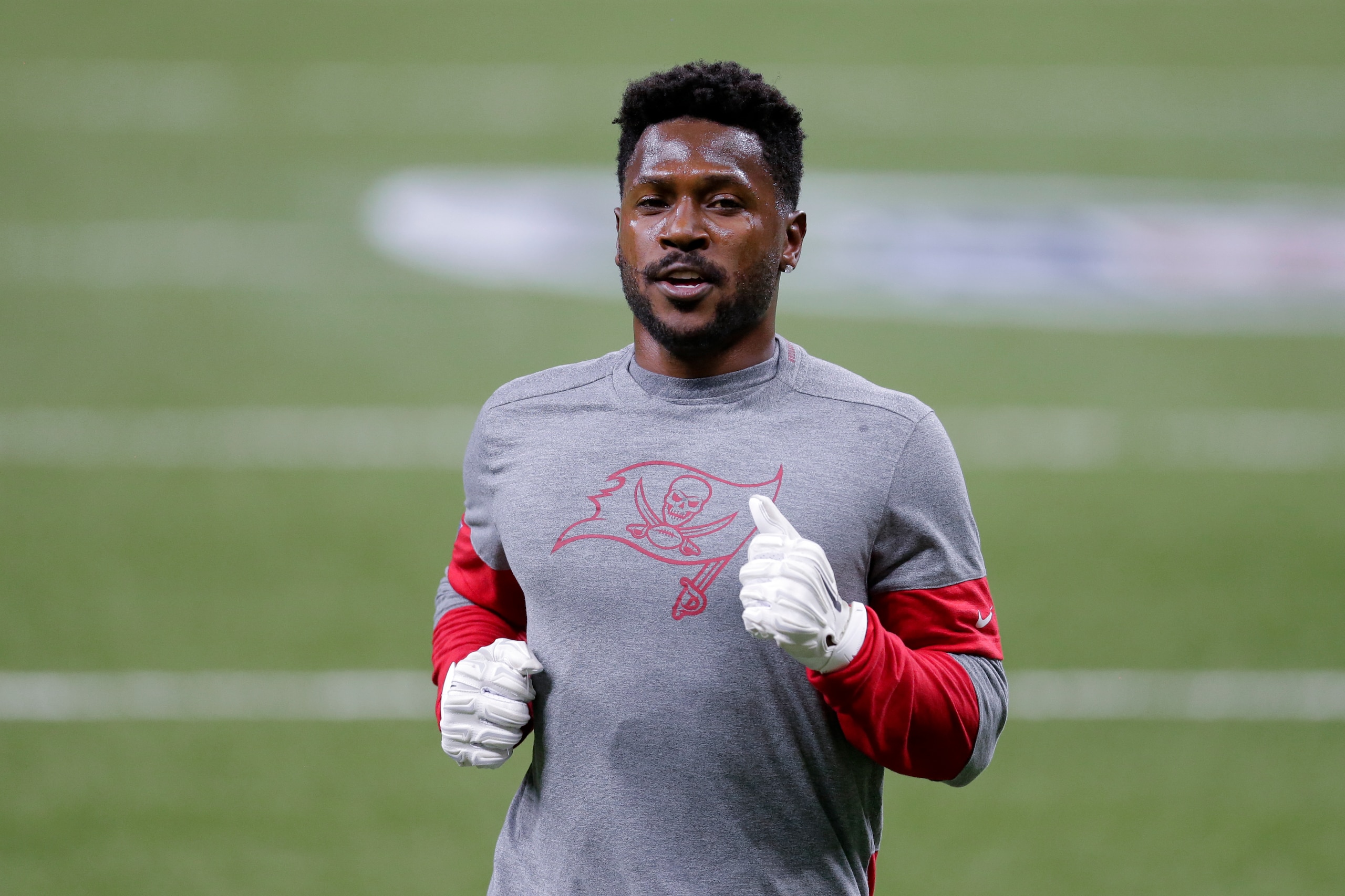 FILE - In this  Sunday, Jan. 17, 2021 file photo, Tampa Bay Buccaneers wide receiver Antonio Brown warms up before the first half of an NFL divisional round playoff football game between the New Orleans Saints and the Tampa Bay Buccaneers in New Orleans. NFL wide receiver Antonio Brown has settled a civil lawsuit by former trainer Britney Taylor, who accused Brown of sexually assaulting her. Taylor filed the lawsuit in 2019, and lawyers for her and Brown released statements Wednesday, April 21, 2021 revealing the agreement. (AP Photo/Brett Duke, File)
