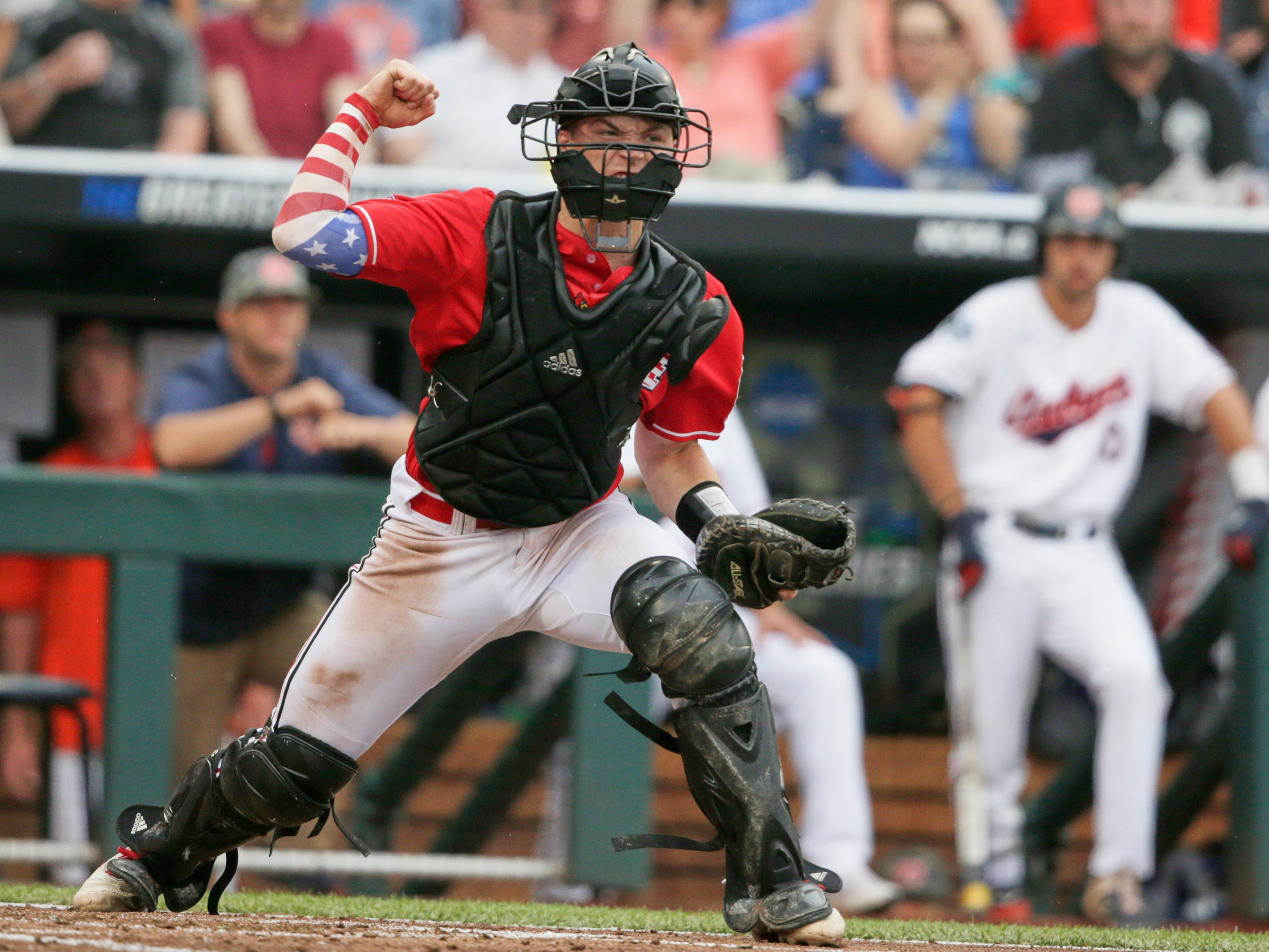 Louisville catcher Henry Davis reacts after tagging out Auburn's Will Holland at home plate by in the third inning of an NCAA College World Series baseball game in Omaha, Neb., Tuesday, June 18, 2019. (AP Photo/Nati Harnik)