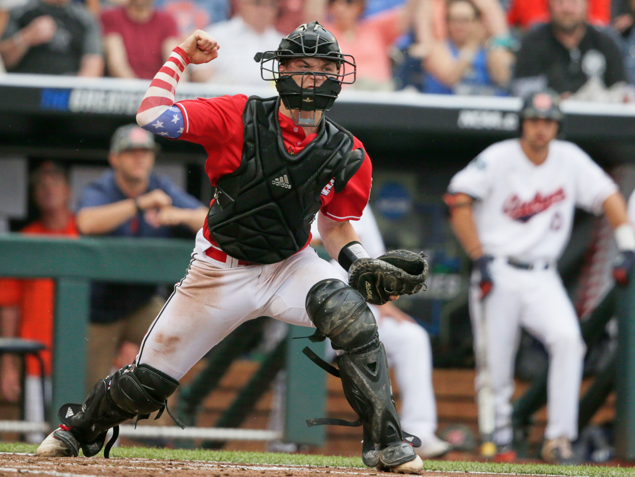 Louisville catcher Henry Davis reacts after tagging out Auburn's Will Holland at home plate by in the third inning of an NCAA College World Series baseball game in Omaha, Neb., Tuesday, June 18, 2019. (AP Photo/Nati Harnik)