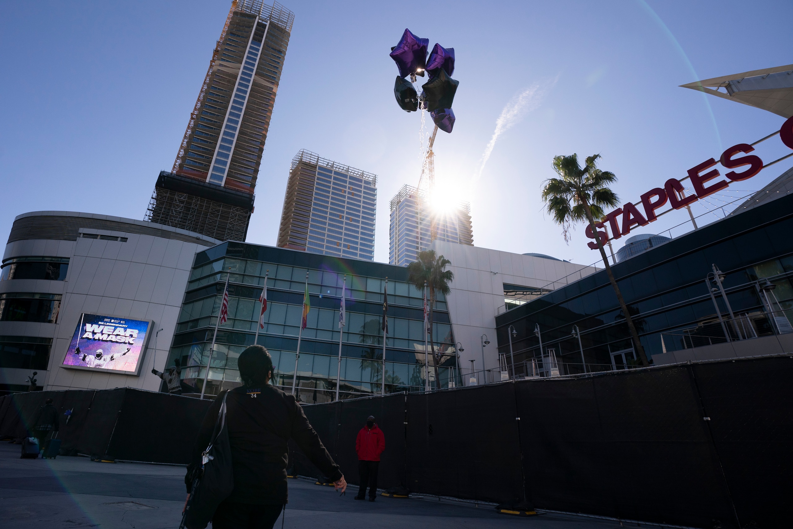 Josie Alvarez, 59, releases balloons into the air to commemorate Kobe Bryant outside Staples Center in Los Angeles, Tuesday, Jan. 26, 2021. Bryant, his daughter, Gianna, and the other seven people who climbed aboard that helicopter on a Sunday morning in Southern California have been gone for exactly one year now — Tuesday marks the grim anniversary of the crash that took their lives. (AP Photo/Jae C. Hong)