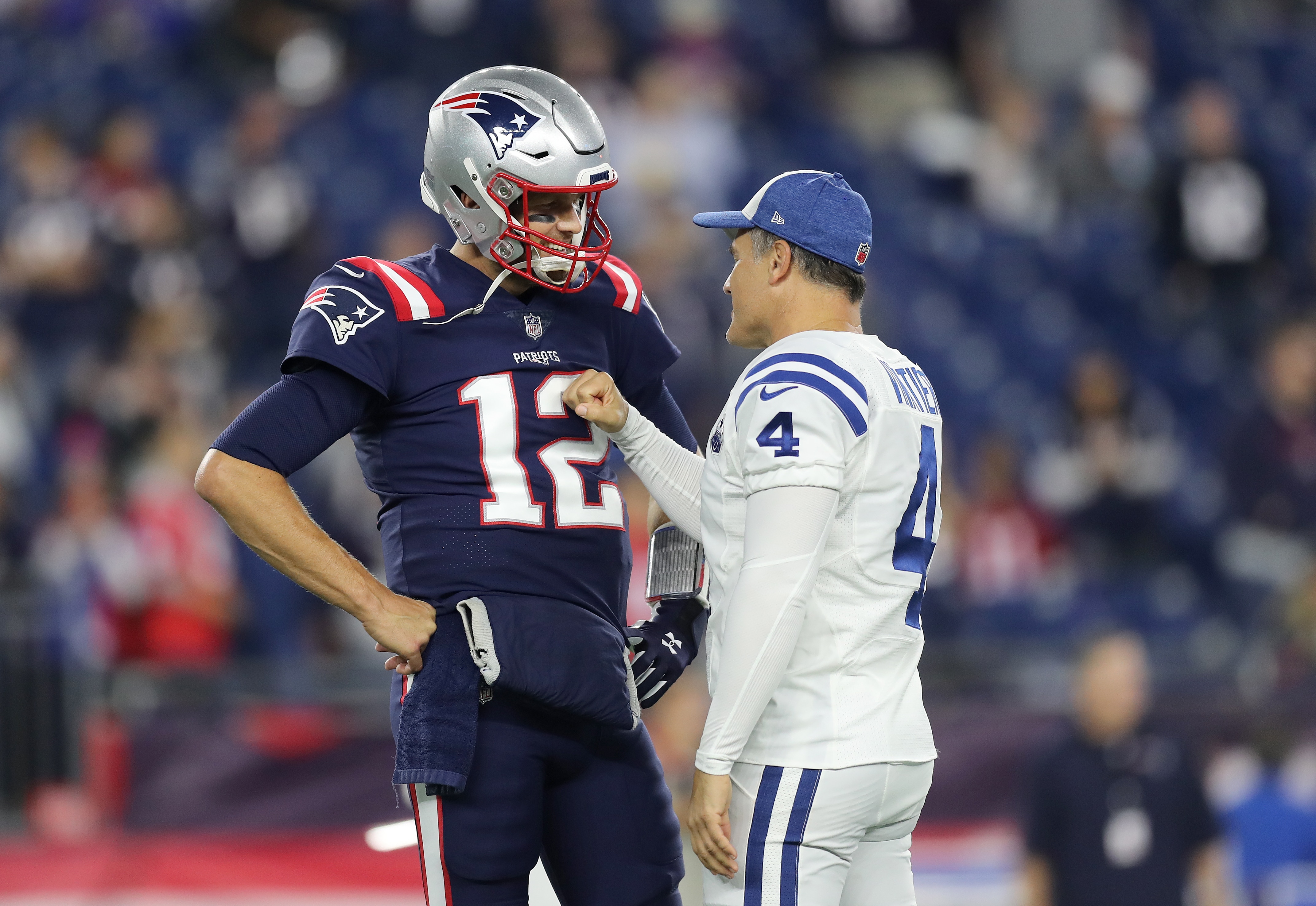 FOXBOROUGH, MA - OCTOBER 4: Indianapolis Colts and former New England Patriots kicker Adam Vinatieri gives a fist pump greeting to Patriots quarterback Tom Brady before the start of the game. The New England Patriots host the Indianapolis Colts in a regular season NFL football game at Gillette Stadium in Foxborough, MA on Oct. 4, 2018. (Photo by John Tlumacki/The Boston Globe via Getty Images)